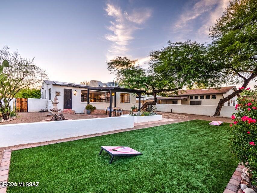 Flexible Fully Furnished Rental Opportunity - Main House $2,000/month | Guest House $1,000/month. Located in a desirable central neighborhood, this charming property offers versatile living options. The main house features 2 bedrooms, 1 bathroom, original hardwood floors, custom Saltillo tile, abundant natural light, and an Arizona room perfect for a home office or additional living space. The landscaped yard includes mature cacti, artificial turf, a patio, outdoor dining area, and one-car carport. The detached guest house includes a private bathroom, fully equipped kitchen, and mini-split system for year-round comfort. Combining historic charm and modern convenience, this unique property is move-in ready and fully furnished.
