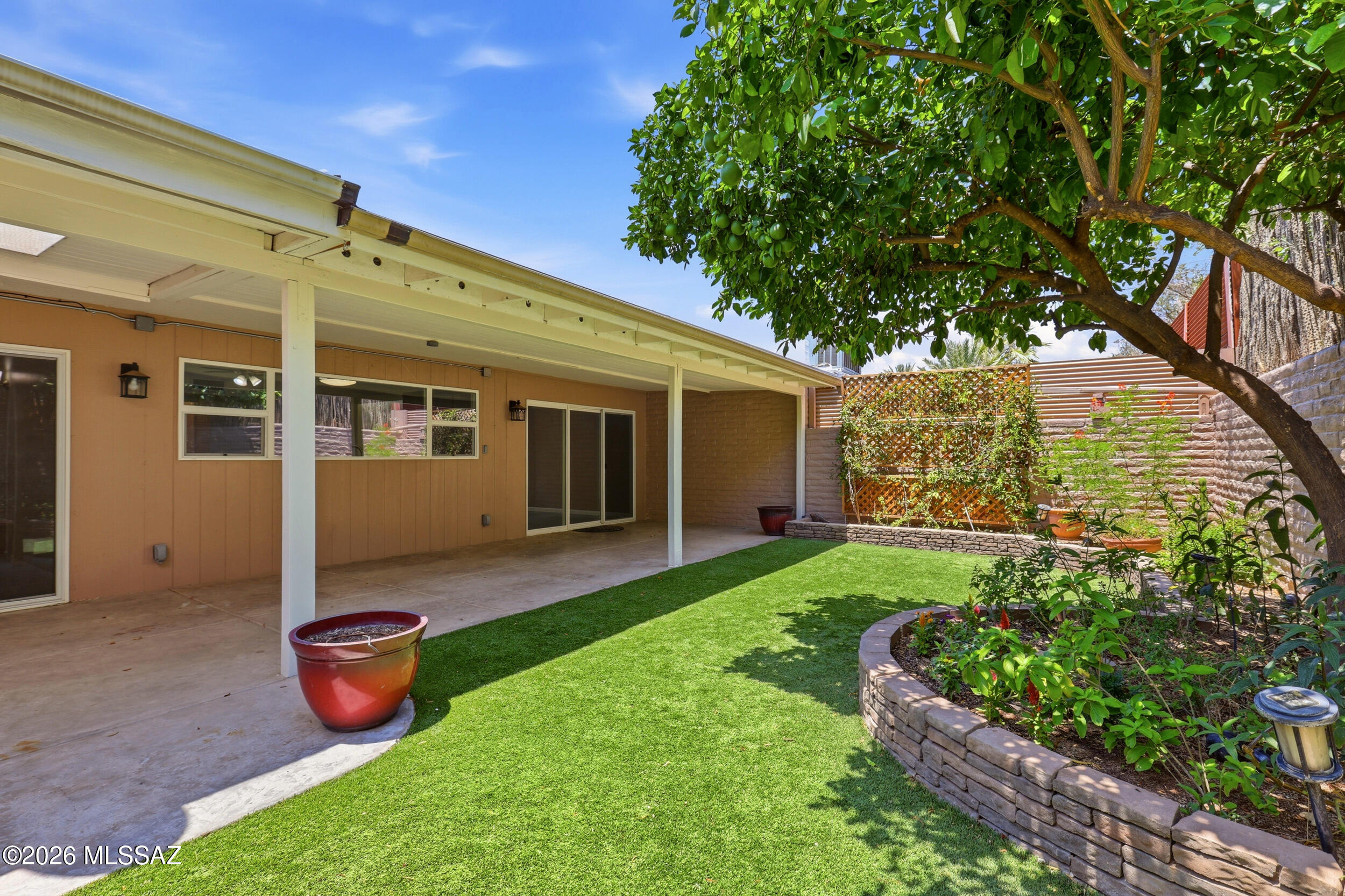Step onto cool ceramic tile past a fireplace faced in stone with a solid mesquite mantel, while high windows carry warm daylight into the living room. The kitchen's 10' window frames the backyard, with the side panes open for fresh air flow. Outside, shade trees and turf make it easy to lose track of time on the full width patio. A newly recoated roof puts your mind at ease. The HOA tends to the front yard and clubhouse gatherings across the street bring an easy sense of belonging to coming home. Local paths tie into the Huckelberry Loop, Udall Park under a mile away, Sabino Canyon about six, dining right around the corner. Seller has relocated and is flexible on closing. Time your showing for early morning and watch that backyard, there's more happening out there than a photo can catch.