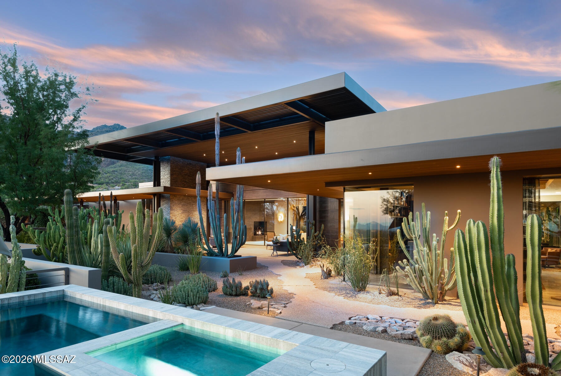 The Querencia Estate in Rattlesnake Canyon: A world-class desert paradise, an architectural wonder, a place where one feels at home. The privately gated desert masterpiece is situated in exclusive Rattlesnake Canyon near internationally recognized Canyon Ranch Wellness Spa & the Ventana Canyon Resort &  Country Club. The only private home designed & built by the renowned architect Ron Robinette, every detail is deliberately designed for private living, harmony with the lush Sonoran Desert, & proximity to the best of Tucson. 73 pristine, saguaro-studded acres bordering Sabino Canyon includes both a main residence & a guest house. The only property of its kind in Southern Arizona, this desert sanctuary is a place that can not be replicated. The landscape is a work of living art, envisioned and composed by celebrated landscape architect John Stropko of New Desert Gallery. The grounds feature a floating cactus garden, meticulously cut natural rock, and imported Swiss window systems framing unobstructed views of the mountains as far as Mexico. Live in your own private canyon with seasonal springs and natural pools, while being just minutes from Tucson's finest dining, upscale shopping, and world-class resort amenities.

RATTLESNAKE CANYON
Rattlesnake Canyon in the Catalina Foothills is one of Tucson' most dramatic natural settings with gentle mountain slopes, cactus-laden rock walls, and exceptional city and mountain views that stretch for miles in every direction. The untouched saguaro-studded hills, and seasonal streams that carve through the canyon will captivate you. Set between two larger canyons, Sabino to the east and Ventana to the west, Rattlesnake Canyon and nearby Esperero Canyon are green jewels of the desert that deliver spectacular views of desert blooms amidst seasonal springs and natural pools.   

THE ARCHITECT
Ronald W. Robinette, A.I.A., is an acclaimed architect and designer recognized for his immense capabilities. Over a dozen times, he has won many popular awards, including "Best Architectural Design" at a prestigious custom home competition, "Street of Dreams," set in Tucson's Honeybee Canyon in 1998. He has also won the "Best in American Living" award and was nominated for "Architect of the Year" in Tucson. 

THE LANDSCAPE ARCHITECT
John Stropko, New Desert Gallery has won countless awards on the local and national level and has been featured in numerous magazines.. He painstakingly created a remarkable desert landscape that blends naturally with the environment while achieving an unmatched level of desert design. 
THE PROPERTY
The beauty and grandeur of the Southwest landscape inspired this 73-acre property. Prior to building, the owners acquired two hillside parcels of land that combined, created this magnificent homesite . To build the home's foundation, landscape designer John Stropko had to remove 30 feet of solid rock, shifting the terrain in the perfect spot between the saddles of two large mountains. Robinette and Stropko worked together to create a masterful property that makes the house look like it was airdropped into the canyon without disturbing the natural beauty of the site. Across the property, you'll find freshly cut rocks, untouched  landscaping, and expertly cured granite.
The single-level, 5,700-square-foot main residence is thoughtfully designed for both privacy and balance, with the owner's suite occupying the west wing and two additional bedrooms positioned in the east wing. Refined materials-marble, travertine, and custom stonework-create a seamless connection between home's structure and aesthetics. These tones harmonize with the environment, and the abundant natural light reinforces the sense that the main house is an extension of the landscape. Terraces and patios unfold to magnificent canyon and mountain views, dissolving the boundary between home and desert landscape. Outdoor grilling, an inviting pool with a spa within, and a floating cactus garden create a pristine environment to enjoy the beautiful Tucson weather year-round. During the monsoon season, the desert blooms bring to life stunning green hues cast from the exterior into the interior for a remarkable display. 
The home is surrounded by a "giant umbrella," as the masterful architect Ron Robinette describes it. A 16-foot steel ramada with wood lattice shades covers the entire home, allowing it to capture the gentle breeze as it passes through the canyon while keeping it shaded. 
Within the complex is a 1,100-square-foot guesthouse in a style that matches the main house. For visitors coming to maintain the property, there is a small landscaper's den with climate-controlled storage and a private bathroom. 
Each mechanical room is controlled with air conditioning to maintain the appliances. In addition, the home features generators to keep the power running in case of an outage.

ENTRANCE AND FOYER
Upon entry, you are greeted with a grand foyer with soaring floating ceilings, which sets the stage and welcomes you into the home. The massive custom metal front door features small windows and is framed by larger windows that stream in natural lighting on all sides. 

THE GREAT ROOM
In the great room, the massive fireplace anchors the space and the surround extends through the roofline and includes a concealed skylight that allows light to wash down. The warm tongue and groove ceiling balance the walls of glass and the stone flooring. It is a wonderful space to enjoy a casual meal or gather around the fireplace for conversation. 

The kitchen is a chef's dream, with exceptional views of the mountains to the north. There is ample pull-out storage, walnut cabinetry, and a Wolf gas range with a double oven and  a flush mount hood vent that seamlessly integrates into the ceiling. In addition to the Sub-Zero refrigerator and the Miele dishwasher there are cooling and warming drawers, for entertaining. The mesquite wood breakfast bar is positioned to enjoy mountain views to the north through the window over the kitchen sink. 

BUTLER'S PANTRY
The butler's pantry offers two wine coolers and a hidden second kitchen. The distressed mirrored backsplash atop light marbled counters opens up the space for serving, storage, and a multitude of uses. A faucet about a foot off the floor with a drain is a convenient place to fill your dog bowls with water. There is a door out to the patio for convenience. 

THE ROOMS
Apart from the owner's suite, each additional room is generously sized, allowing space for a variety of uses, including a home office, home gym, or guest suite. Throughout the residence, custom drapery with a subtle metallic sheen enhances the design's interplay of raw, textured metals and smooth, polished finishes--creating a cohesive aesthetic of understated sophistication.

THE OWNER'S SUITE
The owner's suite features a floating feature wall with shagreen leather panels. The delicate lighting throughout the room allows for adjustments to make the space comfortable and welcoming. 
The expansive closet is a show-stopping feature that offers ample space for clothing and accessories. Beyond the space for clothing is a fold-out ironing board, unique wall storage for handbags, and private jewelry storage. A large mirror can be expanded into three partitions offering full views.
The owner's suite bathroom is complete with two of every feature. Both residents will have access to their own private vanity, sink, and shower. In the middle of the bathroom is a luxurious spa bathtub with exquisite views of the mountains and the desert landscape through a perfectly placed floor to ceiling window.
OUTDOOR LIVING
Expansive wrap-around patios embrace the house,  revealing something beautiful at every turn. The east terrace showcases a waterfall cascading through chiseled rock native to the homesite, while the south patio and yard feature a spool with a spa within and sweeping views that stretch to the Santa Rita Mountains--an ideal vantage point for watching monsoon storms light up the desert sky. Under the covered patio off of the kitchen area, the built-in Wolf BBQ invites outdoor dining and entertaining year-round. The north patio offers generous seating and mountain views, perfect for a relaxed luncheon, an early evening gathering, or a quiet afternoon immersed in a book while you soak up the sun. A 1.5 mile trail that loops around the property is enclosed by a six and half foot fence that provides privacy and security.  

THE GUEST HOUSE
Guests are welcomed into their private oasis through a large covered patio and entry door. The 1,100-square-foot guest house opens up to views that extend into a private back patio that overlook the city. By day, you can see Southern Arizona's many mountain ranges. By night, you can see the city lights flicker in the distance. 

Inside the guest house is a large living area complete with a small kitchenette. A large closet, bathroom, and sleeping area are in the bedroom suite. The imported glass on the doors and windows lines the main living area and bedroom, offers an elegant touch of quality and durability. The guest house has an ensuite bathroom with a large shower and a washer and dryer for your guests. The generous  patio that extends to the south has city views that will make your guests want to extend their stay. A covered parking area is expertly carved out of the rock creating a natural barrier between the main house and guest house that feels ultra-private. 

PRIVACY AND PROXIMITY
Located on two lots spanning 73 acres, the one-level estate is concealed from view, allowing for privacy, protection, and stunning views over Tucson. The expansive front yard blends into the natural landscape, making it ideal for hosting events or soaking up the serene mountain views in total privacy. 
Located just minutes from the Canyon Ranch resort, Ventana Canyon resort, and Sabino Canyon recreation area, you can easily access golf, tennis, pickleball, hiking, biking or a day at one of the most recognized spas in the world within minutes of this property.