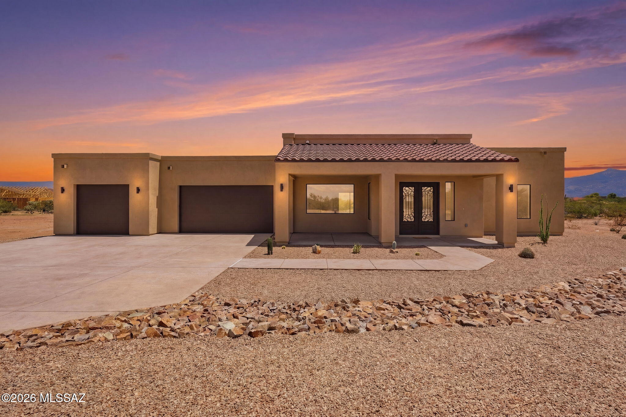 New Construction on 4.6 sprawling acres in Southeast Tucson! Designed with a grand room concept, the living space flows effortlessly into a modern kitchen and dining area where the 12' sliding window showcases panoramic mountain views. An electric fireplace anchors the living room, while high ceilings and ceiling fans in every bedroom keep the atmosphere breezy and bright. Twenty-four-inch tile runs throughout, and dual-paned windows and quartz countertops and lighted/heated mirrors in every bathroom! The split floorplan tucks the Primary ensuite away for privacy, complete with a beautifully tiled walk-in shower, soaking tub, dual vanities and walk-in closet. The guest bathroom might just outshine your expectations, with full-bath amenities that give the powder room a ''POW'' factor!