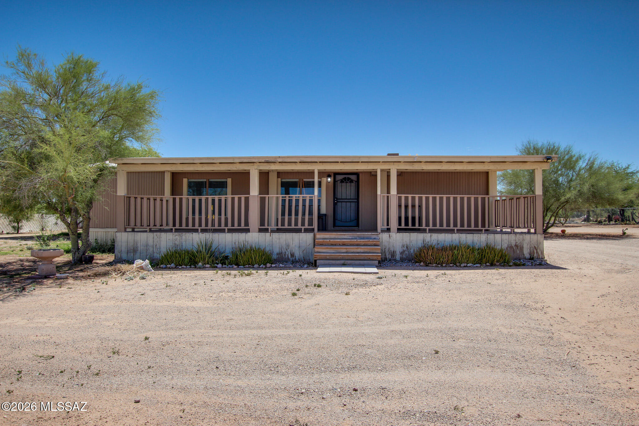 No HOA & One Full Acre of Freedom! Bring your toys, trucks, horses, or big workshop dreams to this beautifully updated 3-bedroom, 2-bathroom home situated on an expansive, low-care desert lot with breathtaking, panoramic mountain and sunset views.
Step inside to an open-concept great room showcasing soaring vaulted ceilings with rustic wood beams and durable, easy-care flooring. The chef's kitchen serves as the heart of the home, beautifully appointed with premium granite countertops, a custom stone-faced breakfast bar, a classic tile backsplash, and premium stainless steel gas range.
The split-bedroom layout features a generous primary suite complete with a custom-organized closet system. Retreat to the spa-like primary bathroom, where you'll find a massive, floor-to-ceiling custom-tiled walk-in shower with dual heads, built-in niches, and a bench seat alongside an updated double vanity. Outside, unwind under your expansive covered porch or patio space and enjoy the quiet rural charm of Tucson living while staying just minutes from city conveniences. This move-in-ready desert oasis offers the space and flexibility you've been looking for!