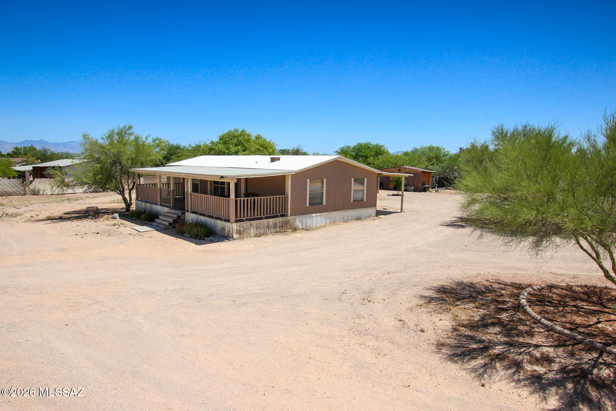 No HOA & One Full Acre of Freedom! Bring your toys, trucks, horses, or big workshop dreams to this beautifully updated 3-bedroom, 2-bathroom home situated on an expansive, low-care desert lot with breathtaking, panoramic mountain and sunset views.
Step inside to an open-concept great room showcasing soaring vaulted ceilings with rustic wood beams and durable, easy-care flooring. The chef's kitchen serves as the heart of the home, beautifully appointed with premium granite countertops, a custom stone-faced breakfast bar, a classic tile backsplash, and premium stainless steel gas range.
The split-bedroom layout features a generous primary suite complete with a custom-organized closet system. Retreat to the spa-like primary bathroom, where you'll find a massive, floor-to-ceiling custom-tiled walk-in shower with dual heads, built-in niches, and a bench seat alongside an updated double vanity. Outside, unwind under your expansive covered porch or patio space and enjoy the quiet rural charm of Tucson living while staying just minutes from city conveniences. This move-in-ready desert oasis offers the space and flexibility you've been looking for!