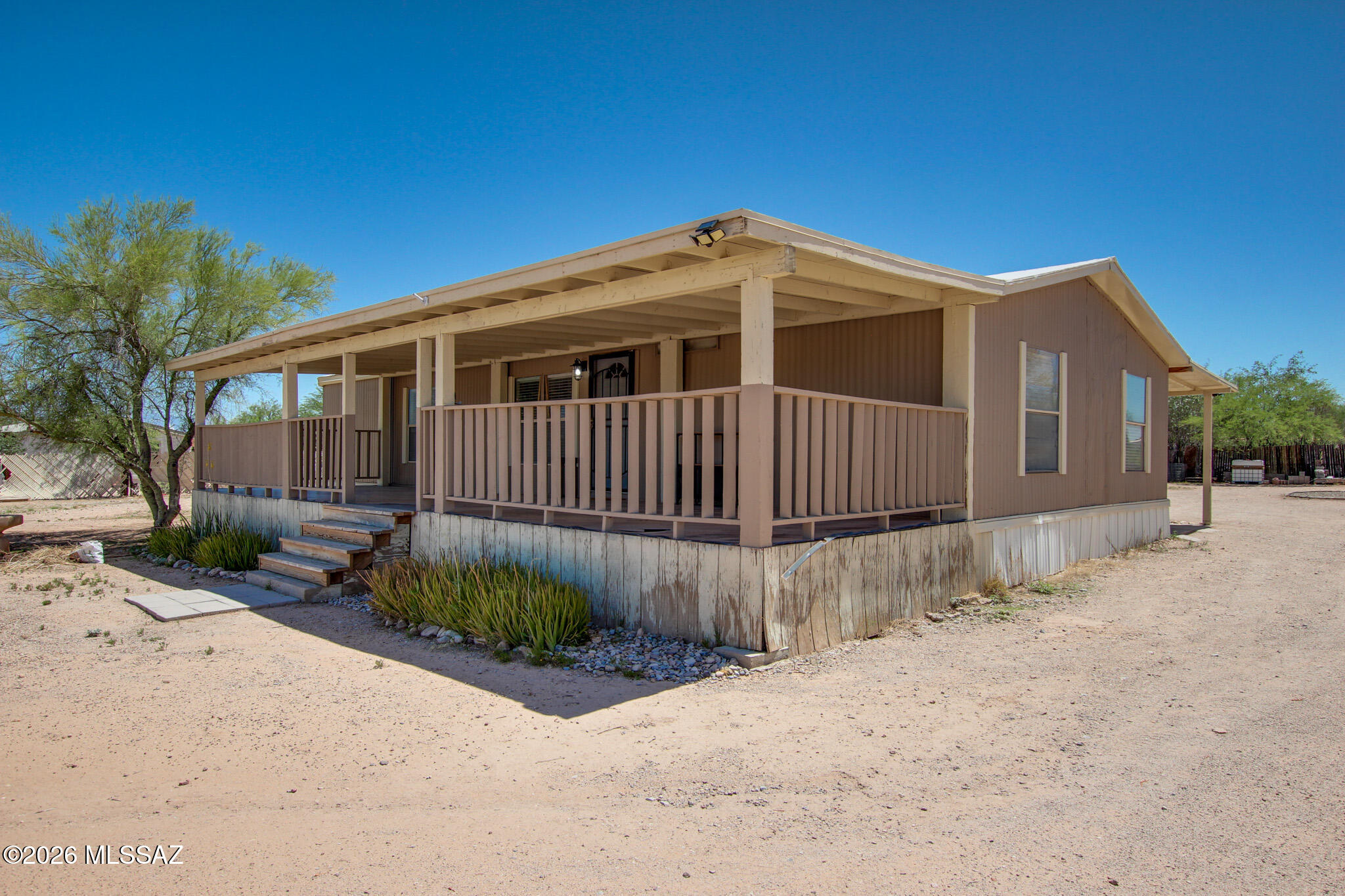 No HOA & One Full Acre of Freedom! Bring your toys, trucks, horses, or big workshop dreams to this beautifully updated 3-bedroom, 2-bathroom home situated on an expansive, low-care desert lot with breathtaking, panoramic mountain and sunset views.
Step inside to an open-concept great room showcasing soaring vaulted ceilings with rustic wood beams and durable, easy-care flooring. The chef's kitchen serves as the heart of the home, beautifully appointed with premium granite countertops, a custom stone-faced breakfast bar, a classic tile backsplash, and premium stainless steel gas range.
The split-bedroom layout features a generous primary suite complete with a custom-organized closet system. Retreat to the spa-like primary bathroom, where you'll find a massive, floor-to-ceiling custom-tiled walk-in shower with dual heads, built-in niches, and a bench seat alongside an updated double vanity. Outside, unwind under your expansive covered porch or patio space and enjoy the quiet rural charm of Tucson living while staying just minutes from city conveniences. This move-in-ready desert oasis offers the space and flexibility you've been looking for!