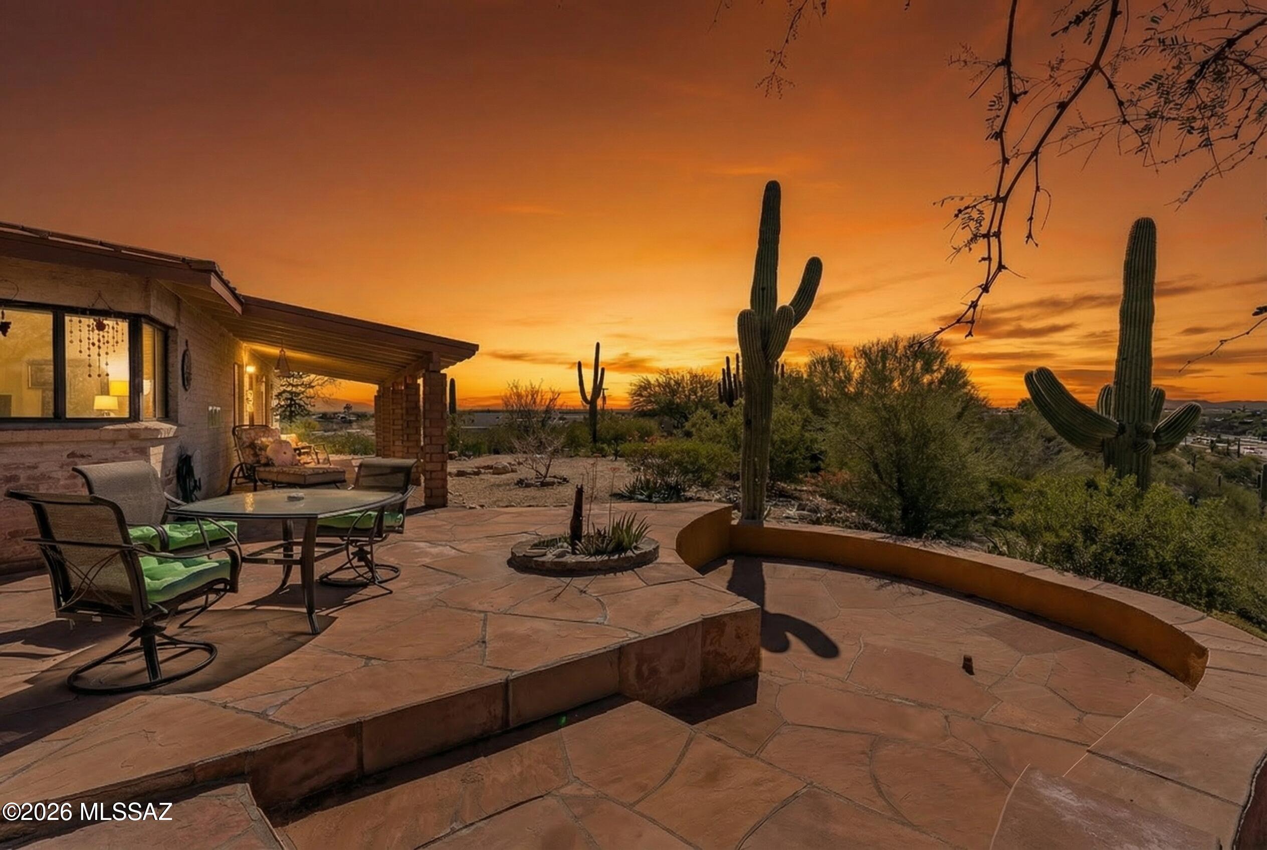 Location location location! Charming 1950's  white-washed brick home on 1.6+ acres of stunning Sonoran Desert w/ 360-degree mountain and city views. Enter through custom all-glass front door into light fill4ed cozy living area w/ fireplace. Kitchen features concrete countertops, GE Profile appliances & a custom hickory wood bar. Two en suite bedrooms, including a primary w/ Jacuzzi tub, plus oversized den & two additional full baths. Beautiful flagstone and stone floors throughout. Meticulously maintained w/ copper roof, HVAC (2021), and new septic (2023). Enjoy a private front patio area w/ fireplace, gas BBQ & Catalina views. Enclosed carport & oversized shed. A rare opportunity to own a private property w/ unmatched views-you'll be proud to call this home!