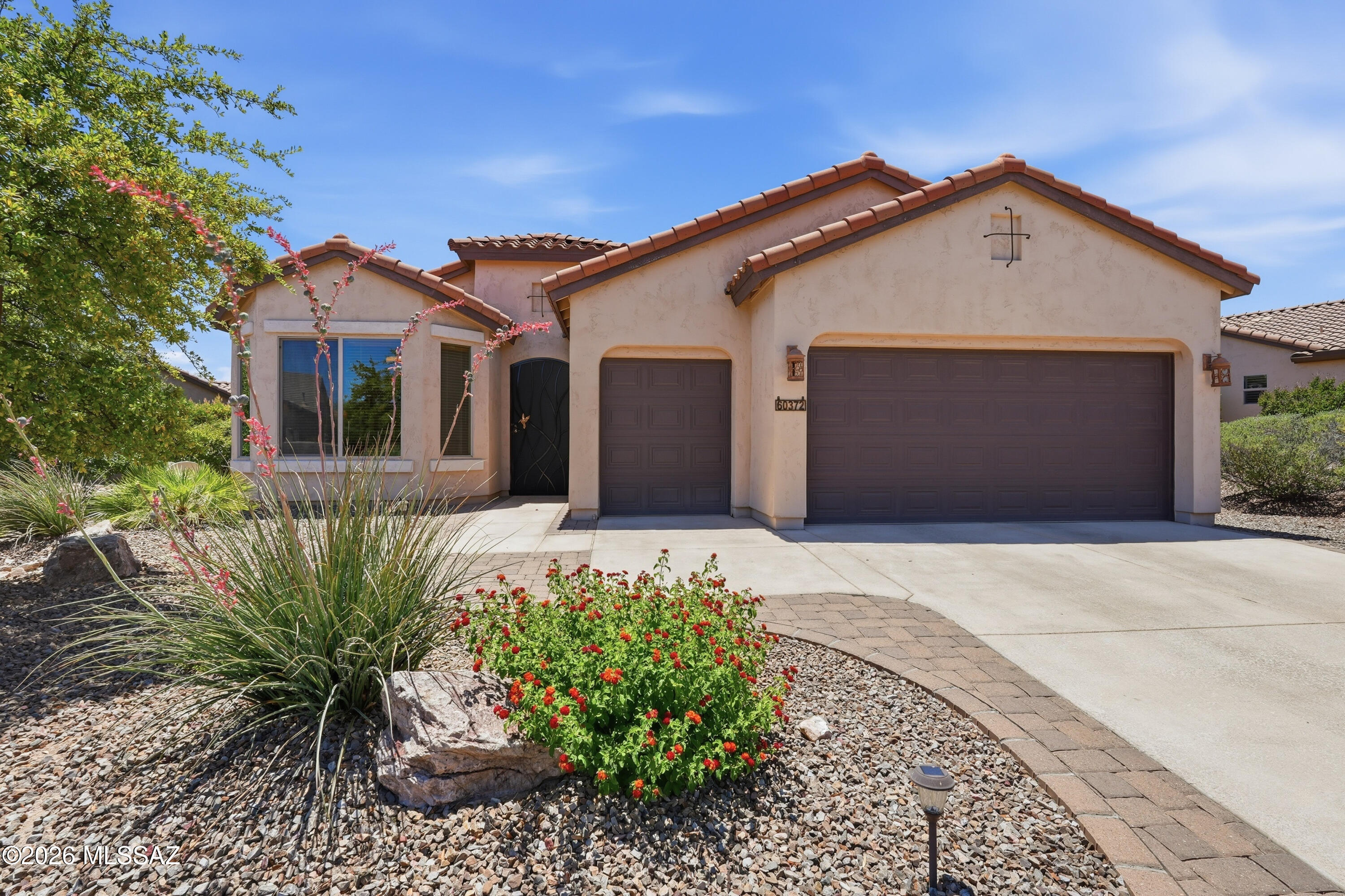 Welcome to luxury resort living at its absolute finest in the premier active adult master plan of SaddleBrooke Ranch! Built in 2014, this beautifully maintained 2BD/2.5BA (1,869 sqft) single-story residence, being sold furnished, perfectly balances casual elegance with everyday functionality, offering a modern desert escape surrounded by manicured high-desert beauty. From the moment you arrive, the home greets you with welcoming desert curb appeal and pristine low-maintenance plantings. Step inside to discover a bright and open great room footprint characterized by high ceilings, ceramic tile flooring, and clean architectural lines that maximize every square inch. Large picture windows draw in an abundance of natural Arizona sunlight, keeping the entire home feeling airy, open, and instantly inviting. The heart of the home is a thoughtfully configured central kitchen featuring a spacious social island, premium countertops, and a seamless flow into the primary living spaces, making it the ultimate hub for weekend hosting or quiet, peaceful evenings. The split-bedroom floor plan is designed for ultimate privacy and daily convenience, offering an expansive primary suite that serves as your private wing. Complete with a generous layout, a massive walk-in closet, and a spa-like private bath, it is the perfect sanctuary to unwind at the end of a long day. The guest accommodations and versatile flex spaces ensure that a dedicated home office, a tech center, or space for visiting family is easily accommodated. Outdoor living is a true delight in the private rear yard. Step out onto the deep covered patio to experience a low-maintenance, professionally drip-irrigated sanctuary, providing an ideal private backdrop for enjoying Southern Arizona's famous colorful evening sunsets or stargazing under Arizona's clear dark skies. Complete with an attached garage and a location just a short golf cart ride away from world-class championship golf courses, pickleball complexes, tennis courts, resort pools, and luxury clubhouse dining, this turn-key residence delivers the active adult lifestyle you have been searching for!