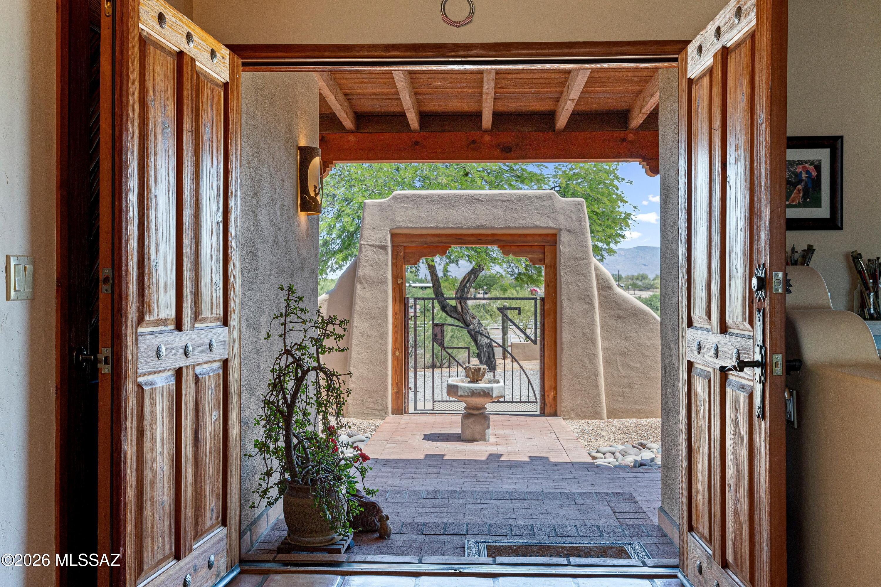 This spectacular Sonoran Desert Estate perfectly blends luxury living with premier equestrian and hobbyist facilities. This property boasts both an impeccably maintained 2800 square foot home and a massive 1,900-square-foot detached workshop/3 car garage/RV garage/heated & cooled, perfect for car restoration, heavy machinery, or a commercial-grade studio. This fully finished area with a half bath, extra storage area, 3 sinks, 2 garage doors and RV height ceilings could be kept as is or easily converted to a large ADU.  Set atop a hill, the 360 degree mountain and city views are one of a kind. This warm, well-cared for three bedroom, three bathroom home has a split bedroom plan and beautiful beamed ceilings throughout. The primary bedroom welcomes you with a lovely beehive fireplace, (MORE) .... separate sitting area, walk in closet and a lovely private bathroom. The kitchen boasts custom cabinetry, a breakfast bar, fireplace, granite counters and a huge copper sink. An expansive walk through pantry connects the laundry room, kitchen and the attached two car garage. Transition seamlessly through any of the rear doors to a backyard paradise featuring a sparkling pool, relaxing spa, and a rare, lush expanse of saguaros and real grass.
Down a small hill you are greeted with a gorgeous four-stall barn perfect for keeping your horses cool and comfortable. A dedicated, secure tack room stores all your saddles and gear while expansive turnout areas allow ample room for exercise and training. Don't miss your chance to call this magnificent property your forever home!