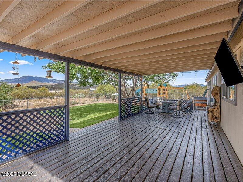 Rare opportunity in this area! This 2,560 sq. ft. home features 4 bedrooms, 2 bathrooms, and open-concept living on a spacious .98-acre lot with panoramic Rincon Mountain views. The kitchen, dining, and family room flow seamlessly for comfortable everyday living and entertaining. Enjoy a large rear deck and fenced backyard with a paver patio, low-maintenance synthetic turf, and a drywalled storage shed with windows--ideal for hobbies or extra storage. The backyard also includes hot tub power hookups for a future spa retreat. A separate side yard offers ample space for RV parking, boats, trailers, or recreational storage. Backyard playset conveys. Agent is related to seller.