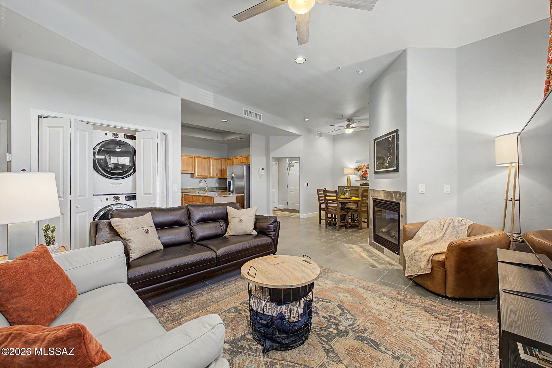 Discover sophisticated urban living in this beautifully appointed 1,291-square-foot corner condominium in Tucson's highly sought-after Sam Hughes Place at The Corner. This stylish third-floor residence features two spacious bedrooms, two full bathrooms, a thoughtfully designed open floor plan, soaring ceilings, abundant natural light, and an open-air corridor with mountain views. Located in an elevator building requiring FOB access, directly across from the University of Arizona and just one mile from Banner Health, the home offers an exceptional blend of luxury, comfort, and convenience. The modern kitchen is fully equipped with granite countertops, sleek stainless steel appliances, a beverage cooler, and a center island with a prep sink and breakfast bar seating, making it ideal for both everyday living and entertaining. Recent upgrades include a new HVAC unit in 2024, new electric range in 2025, new stackable washer and dryer in 2024, updated flooring and a primary bathroom walk-in shower renovation in 2021. Two covered parking spaces are included. The HOA provides extensive coverage including water, gas, security, roof, exterior and common area maintenance, and access to a gym, with only electricity and internet excluded. This spacious, updated, and well-maintained condominium is ideal for full time or seasonal residents, students or investment rental opportunities. Enjoy an unbeatable walkable lifestyle with Trident Pizza Pub, Cheba Hut sandwich shop, Spa Solai, the University of Arizona campus, and the Sun Link streetcar just minutes away, offering effortless access to 4th Avenue, downtown Tucson, shopping, dining, entertainment and recreational areas.   Some furnishings are available on a separate bill of sale.