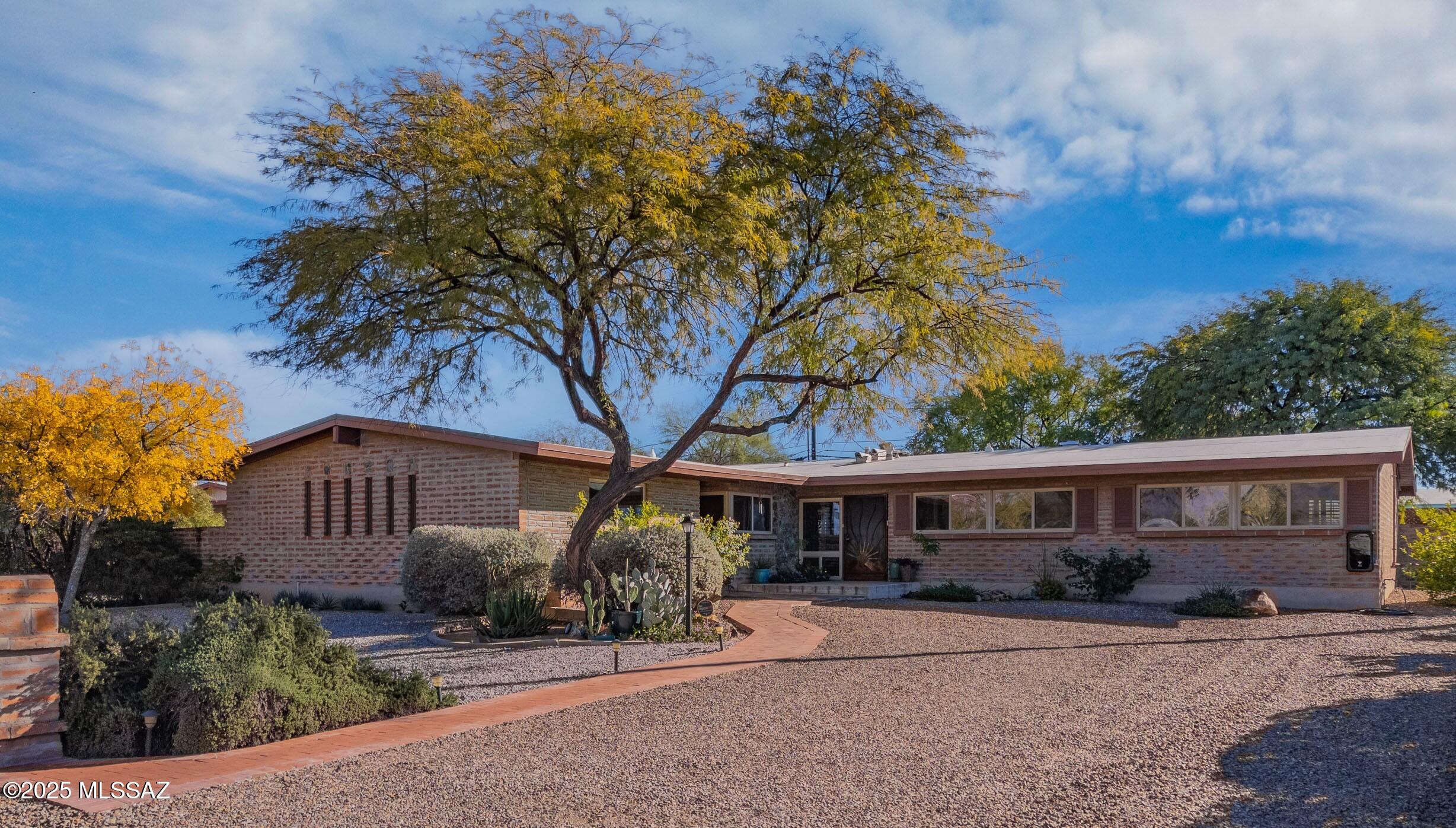 'Range Listing' Seller will consider offers between $575000 & $600000. Thoughtfully designed mid- century home offering flexibility & comfort.  3 spacious bedrooms, 2 & 1/2 bath in one wing, complemented by a private guest suite w/ its own entrance & accessible 3/4 bath.  Dedicated home office provides versatility & can easily serve as  bedroom 5. Multi living areas & a functional floor plan make this property ideal for both everyday living and entertaining. Newer kitchen finished in Cherry & Granite opens to great room w/expansive space for dining. Lots of built -ins for books/collections.  Guest suite has a private entrance, contemporary styled 3/4 bath. Yard has an oasis feel complete w/ Ramada, mature landscaping, & separate yard for your pup.  Don't miss EV charger.