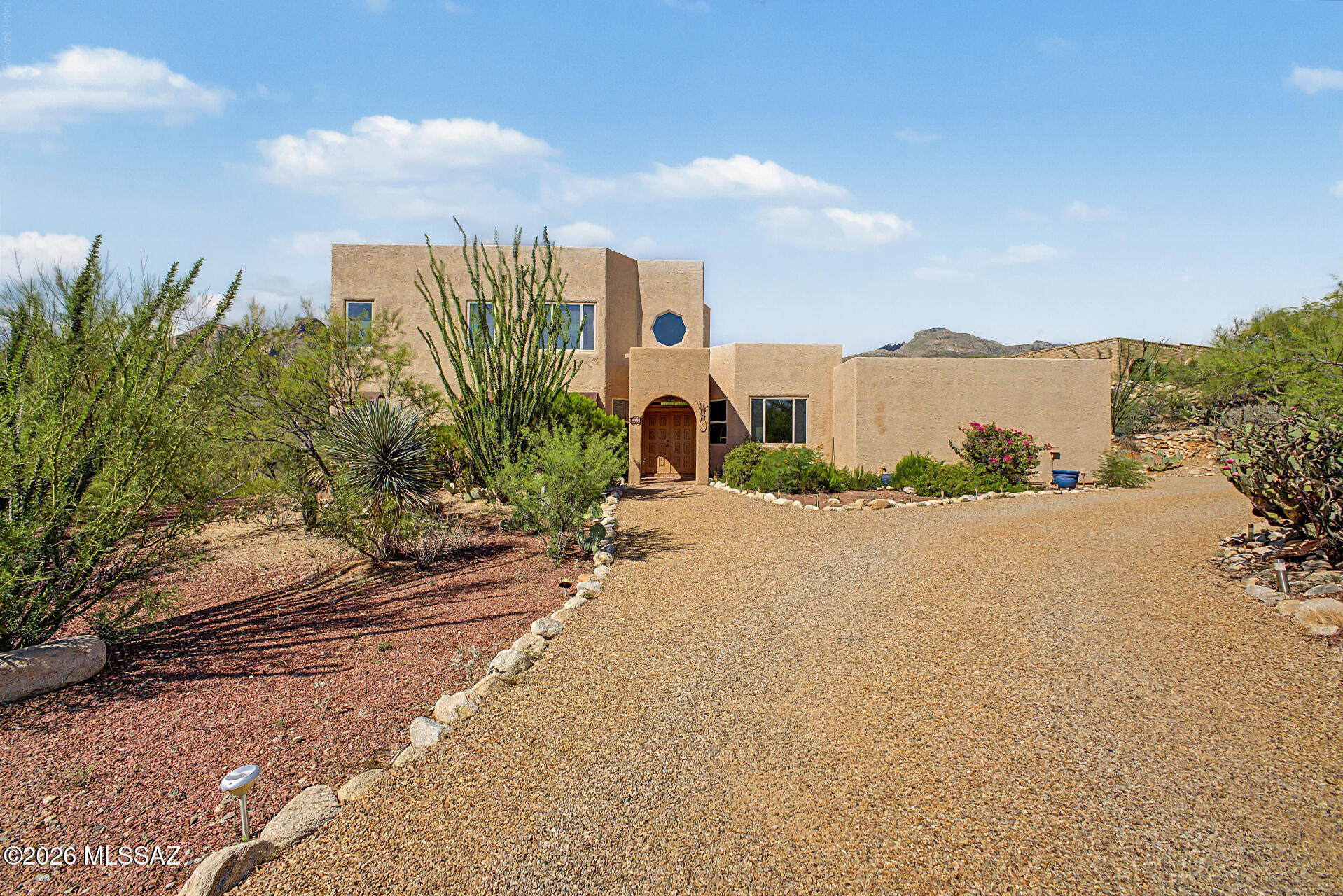 This 3-bedroom, 2-bath home with a 2-car garage, low-maintenance desert landscaping, mountain views. The open living room features vaulted ceilings, abundant natural light, and wood-look flooring. A separate family room with a two-way fireplace offers additional living space, while the formal dining room is ideal for entertaining. The kitchen includes solid surface countertops, Saltillo tile flooring, built-in appliances, and a hanging pot rack. Upstairs, the loft provides flexible space for an office or second living area. Conveniently located near shopping, dining, parks, schools, and easy access to I-10, making commuting around Tucson simple. The primary bedroom boasts a romantic fireplace, a private balcony for taking in the panoramic views, an ensuite with double vessel sinks, and a walk-in closet. Enjoy peaceful afternoons in the backyard, which offers a spacious patio and stylish pavers. Don't miss out on this incredible gem!