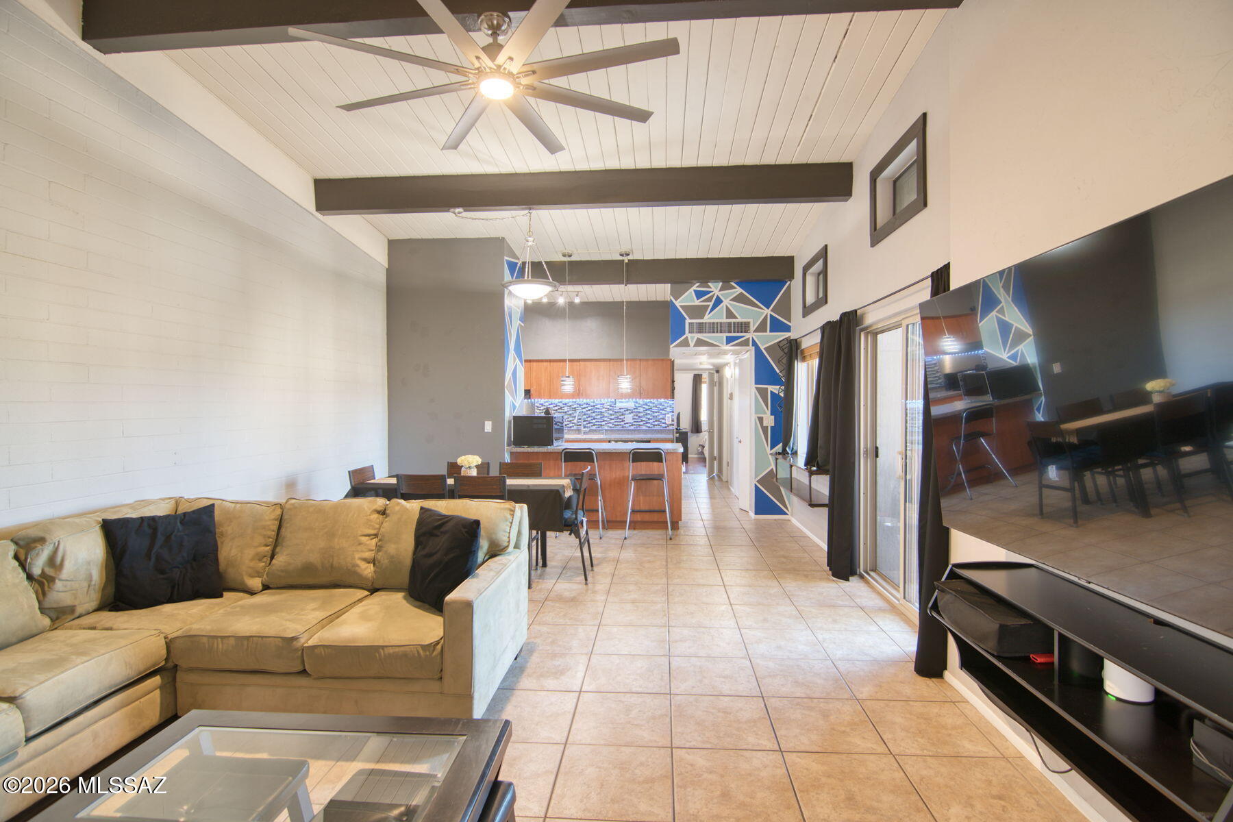 Welcome to this stylish 2 bed, 2 bath condo in the gated Royal Alvernon community! Offering 907 sq ft, this second floor unit features vaulted exposed beam ceilings, an open concept living space, updated finishes, and abundant natural light. The kitchen opens seamlessly to the dining and living areas, while the private covered balcony overlooks the beautifully maintained community grounds and pool. Spacious bedrooms, updated bathrooms, and in-unit washer & dryer included for added convenience. Centrally located near shopping, dining, U of A, and Tucson Medical Center with assigned covered parking and resort style community amenities. Move in ready and perfect for a primary residence, student housing, or investment opportunity
