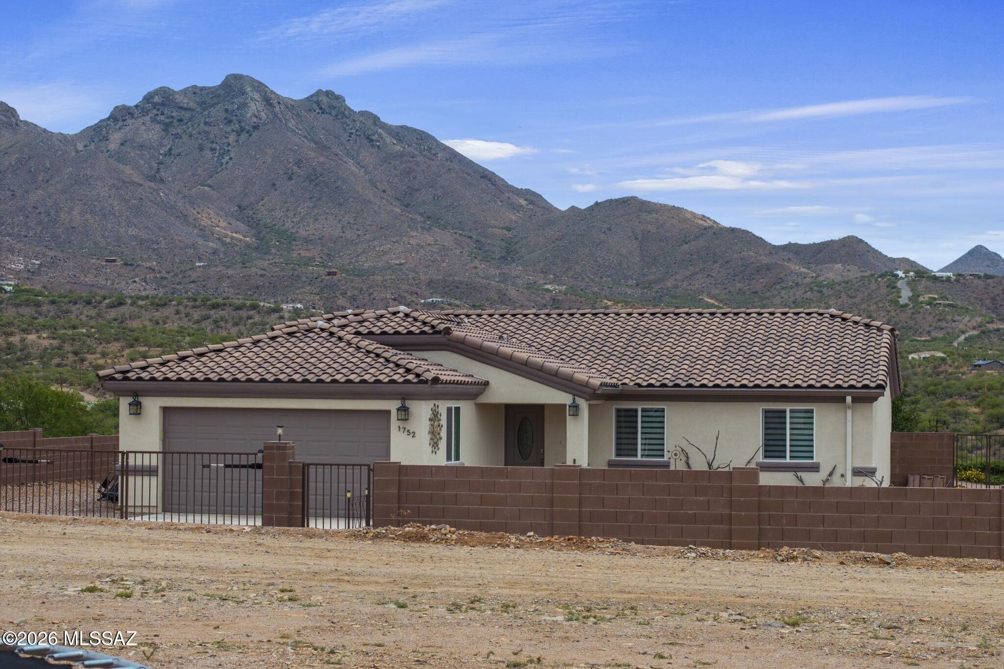 Set against sweeping mountain vistas and backed by two additional lots to create an expansive 1.24-acre homesite, this thoughtfully designed newer Rio Rico residence is located in the desirable Ranchettes community. Enjoy the freedom of no community HOA, plus the potential for additional privacy, room to expand, and space to enjoy the surrounding desert landscape. Beautifully landscaped front and back yards create an inviting outdoor living and entertaining space, with pergola-covered hardscape, cheerful greenspace and raised planting beds. Comfortable interiors feature luxury vinyl plank flooring, custom blinds and upgraded fixtures and finishes. Open-concept gathering space with vaulted ceilings, plus single-level layout offer openness, ease and adaptability to fit every lifestyle.