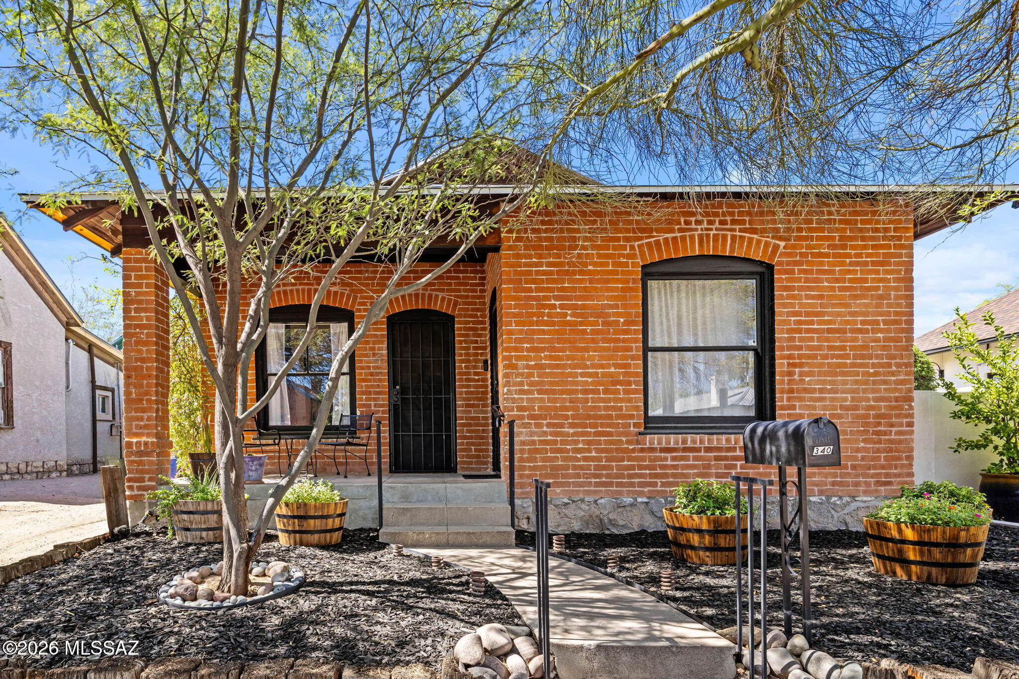 Welcome to 340 E 13th Street, nestled in Tucson's iconic Historic Armory Park District, steps from thriving Downtown Tucson. This 1916-built red brick bungalow has been exceptionally maintained and offers two-bedrooms and one-bathroom in 846 sq.ft. The front yard has been freshly landscaped and the elevated covered front porch is the perfect spot for morning coffee and our beautiful evening sunsets. There are dual entry options with access to the living room or front bedroom. 

The living room is spacious with large windows allowing natural light galore. Pocket doors separate the living room from the formal dining room with original built-ins, not to mention the soaring ceilings throughout. The kitchen offers plenty of counterspace with tasteful white cabinetry and plenty of room for all the essentials. The home is accented with a tasteful combination of hardwoods, sustainable bamboo, and tile flooring. Both bedrooms are spacious and offer walk-in closet spaces and large windows. The back bedroom also showcases the 110-year-old brickwork and new energy-efficient windows. The jack & jill bathroom is tastefully accented with custom tilework, wainscoting, and a clawfoot shower & tub combo. 

The backyard is an oasis, offering a combination of a deck and paver patios with a walkway to the side yard and gated access to the one-car parking space out front. Lush landscape fills the space, including flowerbeds and shrubs. The shed is ideal for storing items you want to keep out of sight. The stucco in the back of the home was recently replaced and painted, offering durability for years to come. The roof was replaced in January of 2025 with transferrable warranty and the brick was extensively repointed in 2025. Other maintenance and upgrades include a two-year-old gas water heater, PEX plumbing, and new sewer line in 2018. Furnishings may be negotiable if desired. 

Downtown Tucson is a thriving destination for dining, local shopping, and nightlife. You also have access to the Sunlink Streetcar that travels as far east as Maingate Square and Banner Medical Center, and as far west as the coveted Mercado District of Menlo Park with plenty of dining, coffee shops, more shopping, and events like the Summer Night Markets, annual Circus, and the Dia de los Muertos procession in the fall, the largest Day of the Dead celebration in the country. I could go on and on. This quaint home offers it all. Come, see, and stay - you won't regret it!