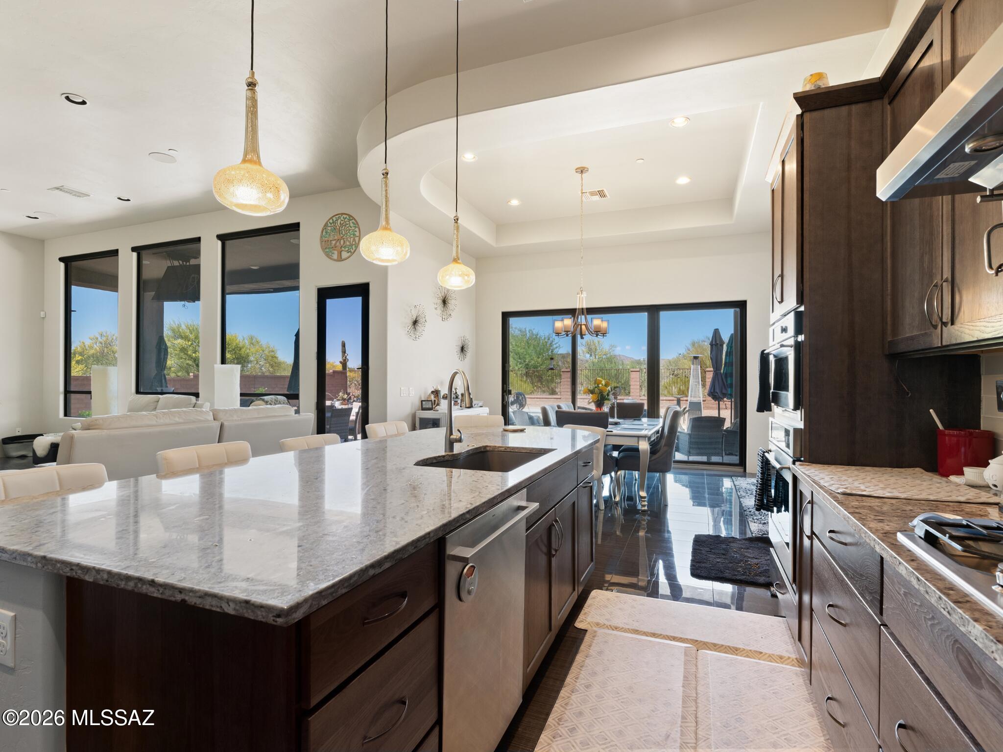 Gorgeous contemporary Oro Valley Home with all the bells and whistles. Integrated smart features throughout. Upgraded indoor - outdoor premium sound system ($15k) integrated within the home and controlled by a tablet. Top of the line Monogram appliances with smart technology featuring wifi connectivity and app (remote) monitoring.
Open floor plan with neutral colors, 12ft ceilings with niches and tray ceilings throughout the home and top-of-the-line materials. Window covering on large picture windows in the great room are remote controlled with multiple opening settings.
Custom storage throughout the home by Closet Trends.
Sightless solar panels were added to the home approximately three years ago - which cuts the electric bill by 60% throughout the year. Central vacuum throughout the home including the garage and workshop space. 

Highly desirable and hard to find climate controlled and insulated 4-car garage ($20k upgrade for insulation) that has an additional 300 sq ft (approximately) of storage/workshop area. Also includes cabinets and countertops built out by Closet Trends. The garage includes a 50 amp Tesla charger and industrial ice maker. 
A portion of the garage could be used for your home gym, pilates studio, man cave, workspace or custom tailored to your own personal needs.

The front yard is beautifully landscaped with desertscape matching the other 26 homes in this beautiful neighborhood. The medium-sized courtyard showcases the morning sunrise over the Catalinas and is ready for the new owners to put their personal touches on it. 

The home beautifully transitions from indoor to outdoor living with your own private oasis where neighboring homes are out of sight. Gorgeous resort-style pool with 4 bar stools and sun shelf seating and umbrella area. The pool is self cleaning and comes with a custom-colored light system controlled by your phone. As mentioned earlier, top-of-the-line sound system and a large television for those who don't want to miss the big game. The pool area has six gas lines installed and ready to go for fire pits and/or tiki torches. There's an additional gas hookup for a BBQ grill. Also has a very large covered patio area that has an additional extendable electronic shade for even greater coverage. A large desert buffer sits behind the home with unobstructed desert views. Both front and backyard drip systems are on timers. There is a water trough behind the open steel fence also on a drip system for those who would like to get a glimpse of the local wildlife in the peaceful mornings or scenic evenings (deer, javelinas, quails, bobcats) 

The subdivision features a community park and fenced dog park. Being in Oro Valley, the home is situated within 5-10 minutes of great public and private golf courses. For bicycle enthusiasts, Oro Valley is connected to the Chuck Huckleberry Loop - a 137 mile car-free paved trail system that connects Oro Valley, Marana and Tucson for bikers and runners alike. Oro Valley is also one of the top spots in the country for stargazing. Because of the town's strict ordinances on light pollution and observatories located nearby, constellations, planets and even the Milky Way are visible to the naked eye.