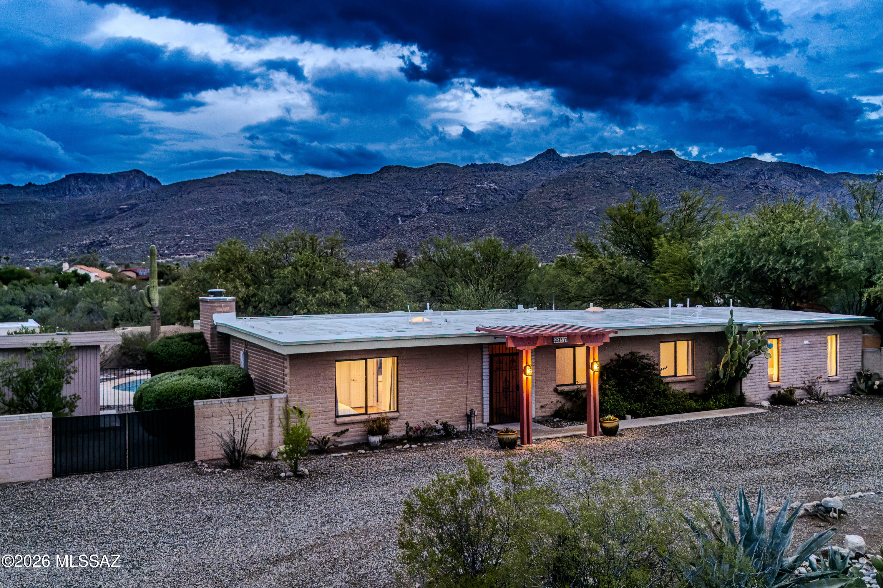 Beautifully updated and set on 1.04 acres at the base of Mount Lemmon in the highly sought after Tanque Verde Valley, this exceptional 4 bedroom, 3 bath home captures breathtaking Catalina Mountain views and offers a highly desirable split floor plan with two private primary suites on opposite sides of the home, ideal for multigenerational living, guests, or added flexibility.

Natural light fills the home through multiple French doors, creating a seamless connection between the inviting interior and the surrounding desert landscape. The spacious layout features a fireplace, formal dining area, Arizona room, and a beautifully updated kitchen with concrete and aggregate countertops, a butcher block breakfast bar, open shelving, subway tile backsplash, and custom lighting from Sun Lighting Recent improvements include a new roof on both the home and detached garage, HVAC system, upgraded electrical panel, fresh interior paint, updated bedroom flooring, a new refrigerator, and refreshed desert landscaping.

Step outside to enjoy multiple patios, including private patios off the primary suite and Arizona room, plus a spacious patio overlooking the sparkling pool with deck jet fountains. Citrus trees, rose bushes, a mesquite grove, and expansive mountain views create a peaceful backyard retreat that is equally suited for entertaining or quiet evenings at home.

A detached two car garage with extensive built in cabinetry and workshop space adds exceptional versatility. Whether you're relaxing by the pool, enjoying your morning coffee on one of the private patios, or watching the sun set behind the Catalina Mountains, this home offers the privacy, views, and Arizona lifestyle you've been waiting for.