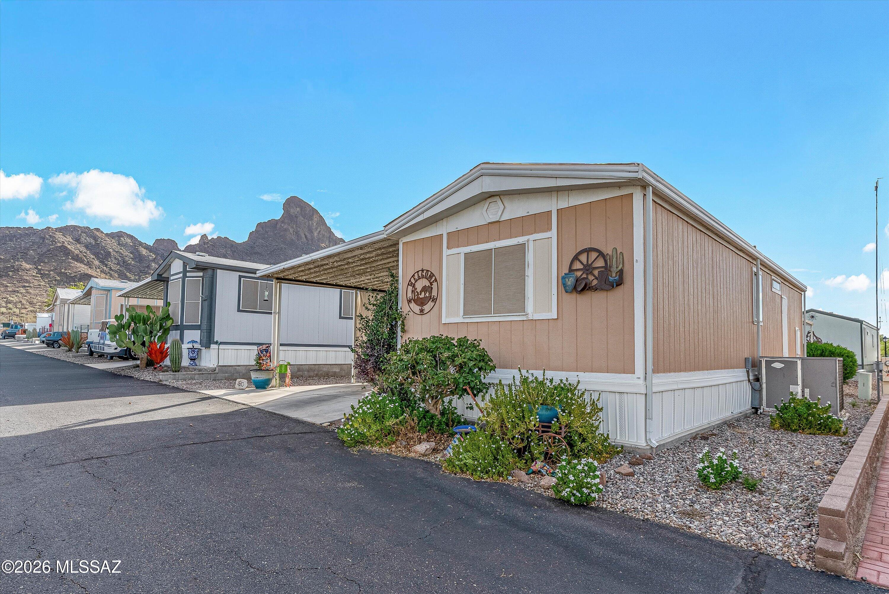 Turn-key and fully furnished, this 1994 park model is located in the desirable 55+ Picacho Peak Resort. The bright, open floor plan features an inviting living room, spacious kitchen with upgraded stainless steel appliances, recessed lighting, a new oversized kitchen sink, updated dishwasher, and a comfortable dining area. The bedroom offers generous closet space, while the bathroom includes a newer faucet and toilet. Additional upgrades include smart bedroom lighting, fresh interior paint, and a recently repainted exterior with durable metal siding. Enjoy the large covered carport, private patio and storage shed. Land Lease!