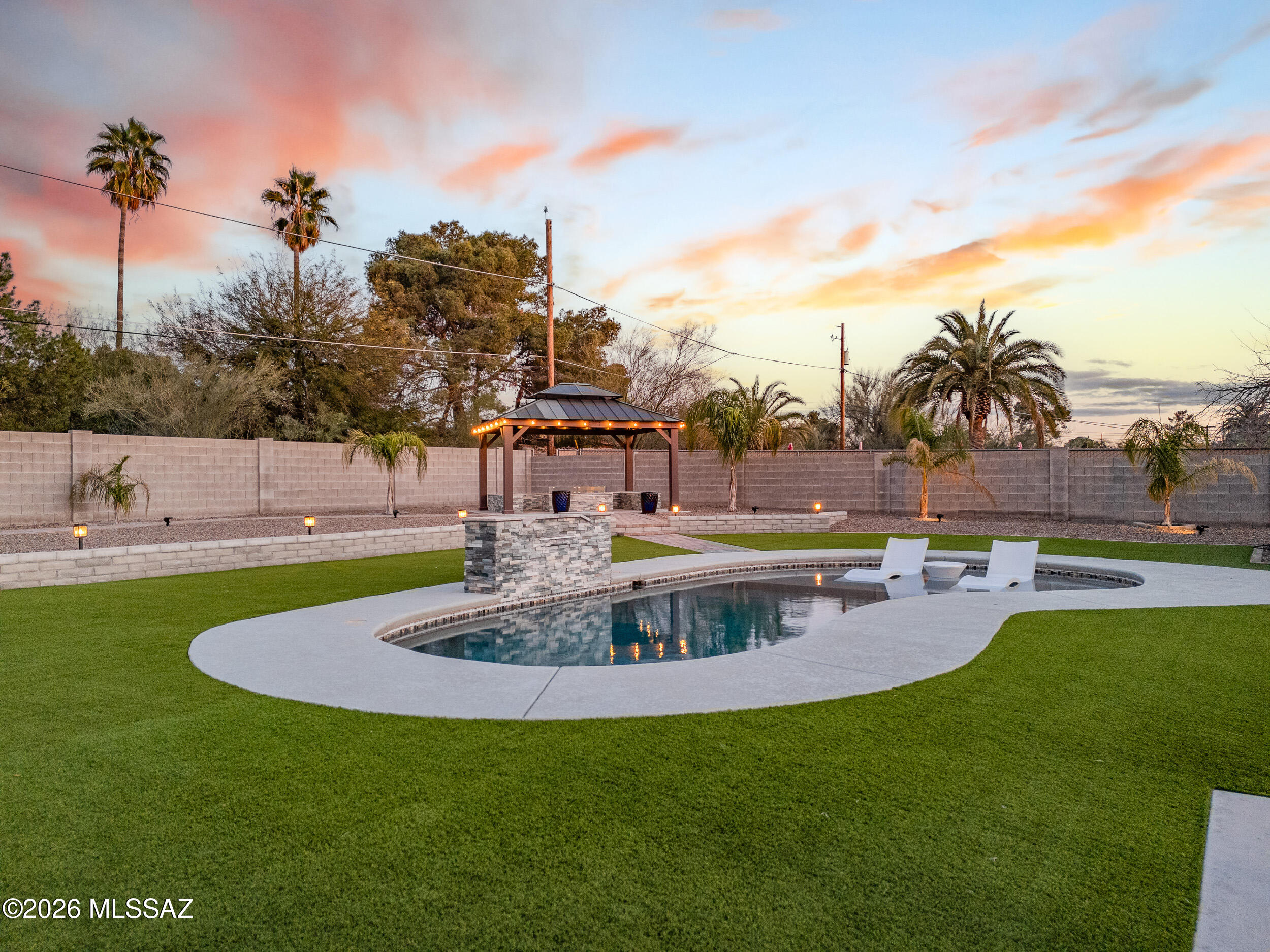 Welcome to one of Central Tucson's most exceptional offerings-set behind walled, elevated, and gated grounds that create rare privacy and presence. This 3 bed, 3 bath home with a 2-car garage blends timeless design with resort-style living. Inside, thoughtfully curated interiors deliver warmth, flow, and function with beautifully designed living spaces ideal for everyday comfort and entertaining. Step outside to a true backyard beach-style oasis featuring a sparkling pool,fire pit, lush turf, ambient lighting, and multiple lounge areas--perfect for sunset gatherings or quiet evenings under the stars. All of this just minutes from Tucson's best dining, shopping, entertainment, and cultural amenities. A gem that feels like a private retreat while keeping you close to everything tucson offers
