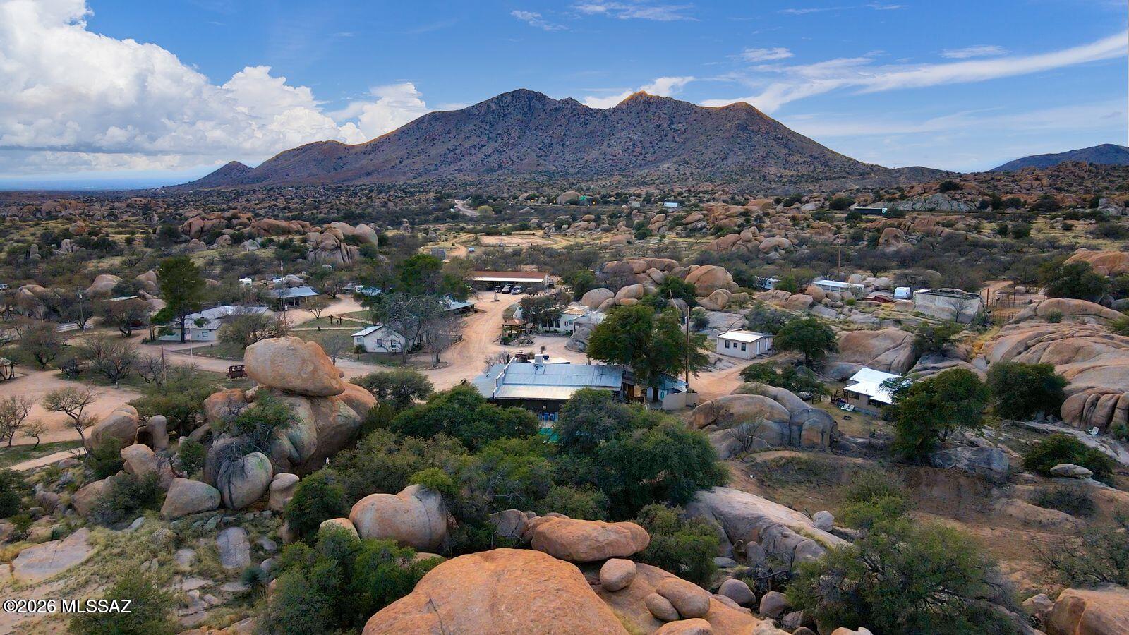 Step into the legacy of the American West at the historic Triangle T Guest Ranch, a rare 160-acre retreat nestled among dramatic boulder formations and ancient oak trees in scenic Texas Canyon. One of Southern Arizona's oldest guest ranches with 11 casitas, 15 full RV spaces, the most amazing and famous Rock Saloon, a restaurant with full commercial kitchen, pool, great horse facilities and an owner's residence. This storied property offers a unique blend of natural beauty, rich history, and established hospitality infrastructure. Set at a comfortable 4,800 ft elevation with a mild year-round climate-approximately 10 degrees cooler than nearby Tucson-the ranch has long attracted outdoor enthusiasts, artists, and travelers seeking an authentic Western experience. Surrounded by the striking landscapes of the Little Dragoon and Dragoon Mountains and within easy reach of the Chiricahua Mountains, Cochise Stronghold, and Kartchner Caverns, the location is ideal for hiking, horseback riding, birdwatching, and exploration. Steeped in cultural and historical significance, the property neighbors the Amerind Foundation and includes ties to Native American heritage, with petroglyphs and sacred ceremonial sites among the rock formations. The ranch also holds a fascinating place in American history, with documented use during WWII, notable guests, and a long-standing presence in film and television production. Designed for both lifestyle and income-generating opportunity, the ranch supports a wide range of established and repeat uses. It has hosted weddings, reunions, and retreats of all kinds-including wellness, corporate, religious, and rehabilitation programs-along with long-running annual events, festivals, and competitions. The property is a recognized destination for motorcycle groups, RV clubs, equestrian clinics, and outdoor sporting events, and has accommodated corporate clients, extended-stay guests, and large group functions.
Significant value-add opportunity exists through modernization of marketing and digital presence. The ranch has historically operated with minimal online footprint and limited social media engagement, relying primarily on word-of-mouth and repeat clientele. A new owner can capitalize on existing demand by implementing updated website functionality, digital booking systems, and targeted marketing campaigns to increase visibility, occupancy, and revenue.
With infrastructure suited for gatherings both large and small, the ranch regularly welcomes nonprofit fundraisers, youth and community organizations, artist and photography groups, and specialty interest clubs. Its location along a seasonal bird migration path, dark-sky conditions for stargazing, and expansive terrain further enhance its appeal for nature-based programming and experiential tourism. Equestrian facilities include a regulation-size arena, riding trails, and obstacle course, with the rare advantage of allowing guests to bring and camp with their own horses. Additional features include dry camping areas, employee RV accommodations, and flexible event spaces-supporting everything from multi-day clinics to music festivals and private celebrations with live entertainment. Whether envisioned as a boutique resort, event destination, retreat center, or private legacy property, the Triangle T Guest Ranch offers unmatched character, proven versatility, and exceptional potential in one of Arizona's most iconic landscapes.

3 Tax Parcels: 208-58-002N, 208-58-002P, 208-58-002L.