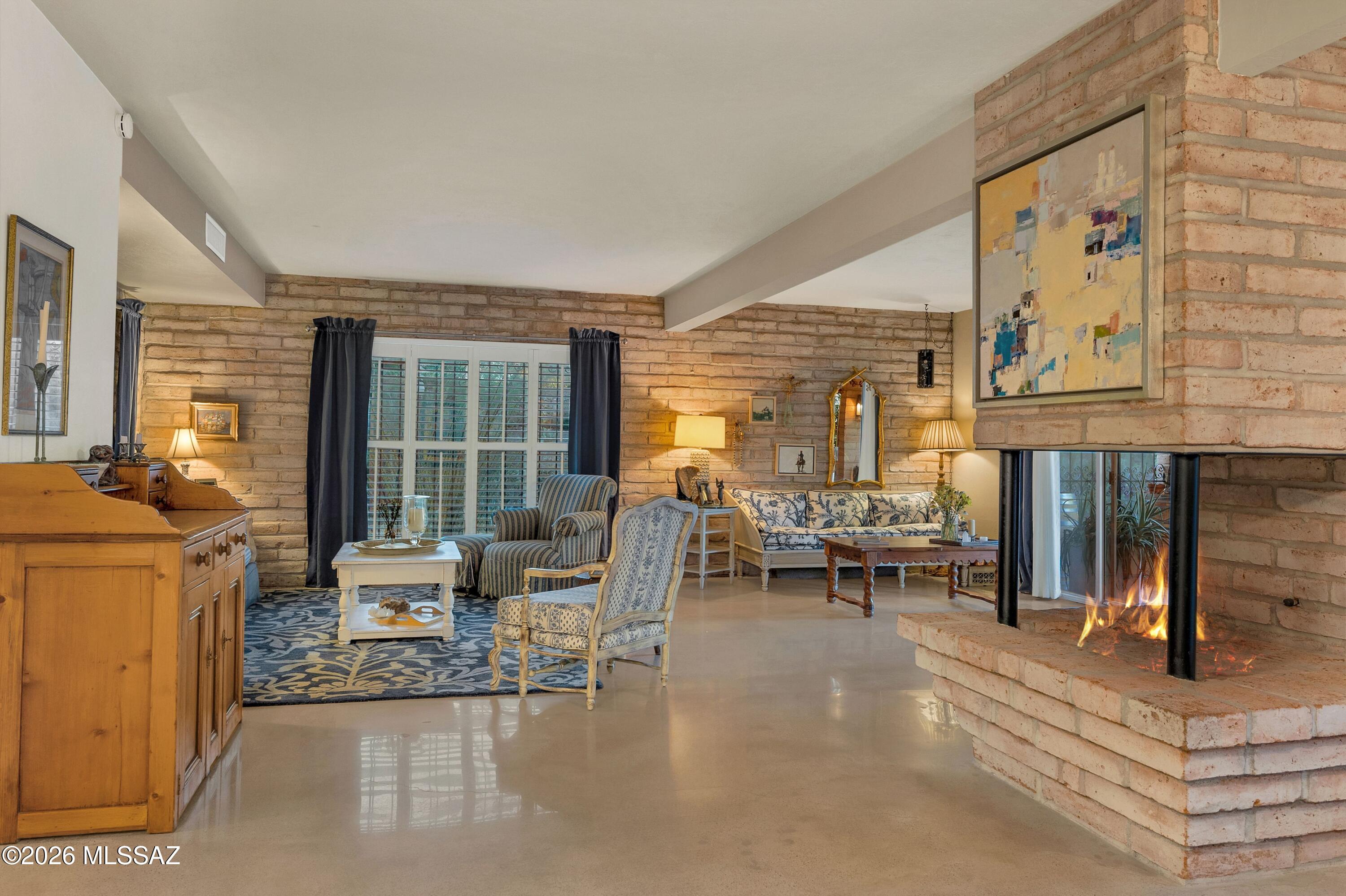A rare opportunity in gated Skyline Country Club with stunning mountain views.  An adobe treasure that was renovated with the eye of an artist. Exposed brick walls, striking central fireplace, and a myriad of glass doors and windows opening to large covered patio and courtyard.  Of course ,the result is a light and airy ambiance that brings the outside in at every turn. A remodeled kitchen that defines the ''heart of a home'',Custom cabinetry, quartz counters, farmhouse sink, and my favorite...a beautiful red stove!  Off the kitchen is such a great flex space....a breakfast area? an office?Or just perhaps a spot to sit and read? Steps away is the golf course with set times to walk.  I am a native Tucsonian and this home called to me from the moment I entered.  I wouldn't miss this one.