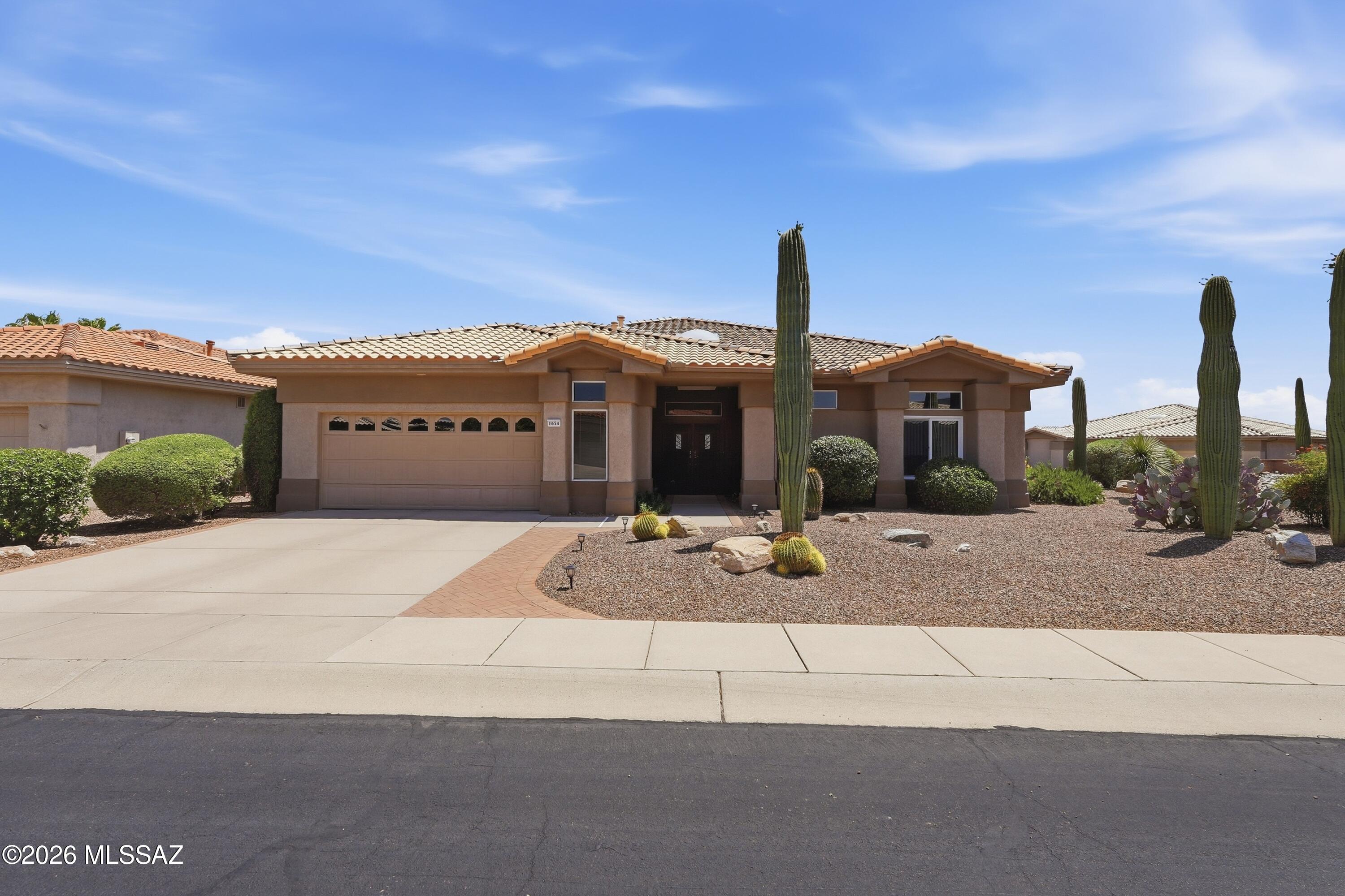 Discover the ideal blend of gorgeous mountain views and resort-style living nestled in the active adult community of Sun City Oro Valley. This 3BD/2BA+Office/Hobby Room (2,237sqft) beautifully designed contemporary residence masterfully maximizes single-level living with an abundance of natural light and zero interior steps. The home features an exceptionally fluid open-concept layout that seamlessly connects the main living spaces. At the heart of the daily routine is a welcoming living room off the kitchen, complete with a cozy gas fireplace that creates the perfect focal point for cool desert evenings. For hosting more formal gatherings, the layout boasts a combined formal living and dining area. This home uniquely prioritizes modern work-from-home or hobby needs by featuring three spacious bedrooms plus a dedicated separate office space. The private primary suite serves as an ideal retreat, showcasing an expansive layout, a large walk-in closet, a master bath complete with a deep garden tub, and a separate walk-in shower with bench seating. Step outside to experience a serene and manageable outdoor haven situated on a desirable, elevated, corner lot. The rear yard is fully wrapped in secure slump block view wall, keeping the space private while allowing the beautiful desert breezes to flow through. Relax on the covered back patio or dine alfresco on the extended paver patio area, all framed by low-care desert plantings. Living on Crown Ridge Way awards you front-row access to beautiful mountain views, and a rich community lifestyle. You are less than a mile from premium neighborhood features, including the recreational walking trails at Honey Bee Park. With comprehensive access to tennis courts, swimming pools, pickleball, and athletic centers, this residence delivers the ultimate active-adult lifestyle. Views!