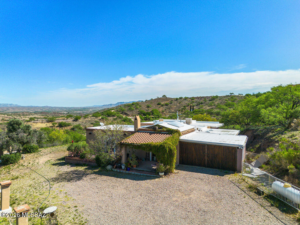 Own a piece of Arizona history. This Mexican Hacienda style estate is perfectly perched in the rolling hills of Nogales Mountain View and unmatched privacy from the patio, where you may also see a deer. The home soul is found in its exceptional historical features: the massive ceiling beams sourced from an underground mine in historic Bisbee, cooling thick, masonry walls, inside and outside the library features original windows from a landmark Nogales Icehouse. Picture this: your morning, coffee in the atrium, a relaxing, hot tub, you buy and put in the step down spa room, an evening with friends around the fireplace, a fiesta with friends in the spacious living room.  Come See Enjoy!
