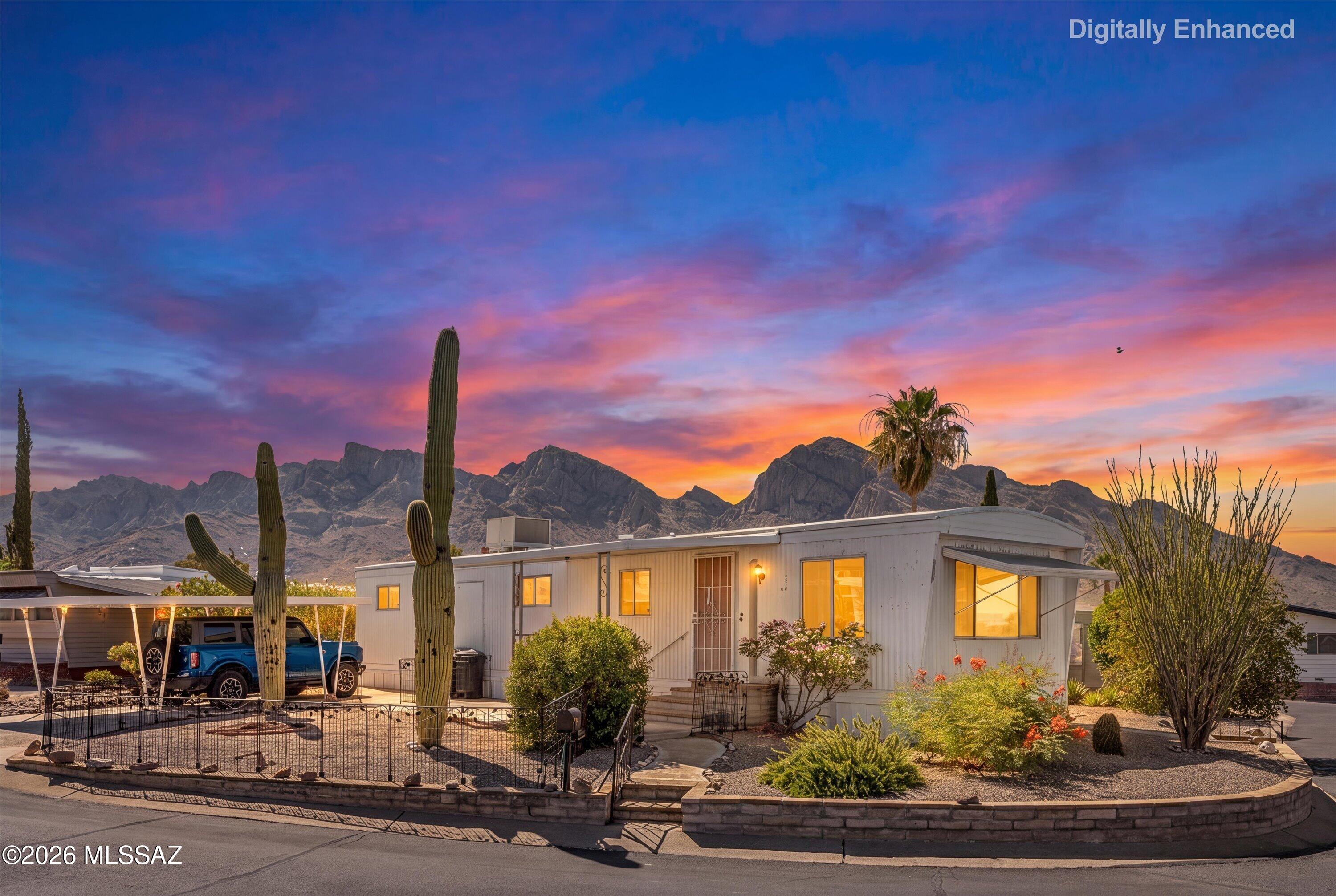 Set against a dramatic mountain backdrop, this 2-bed, 1.5-bath mobile home offers comfortable living with inviting indoor and outdoor spaces in a 55+ community. A spacious Arizona room provides additional flexibility for hobbies, relaxation, or entertaining, while large windows capture natural light and views of the surrounding desert landscape. The living room flows into the kitchen, featuring ample cabinet storage, generous counter space, and a gas range. The primary suite includes an en-suite bath, and the secondary bedroom is conveniently located near the main bath. Outside, the low-maintenance desert landscaping is accented by mature cacti, flowering shrubs, and covered parking. Additional features include a dedicated laundry in external storage, and mountain views.