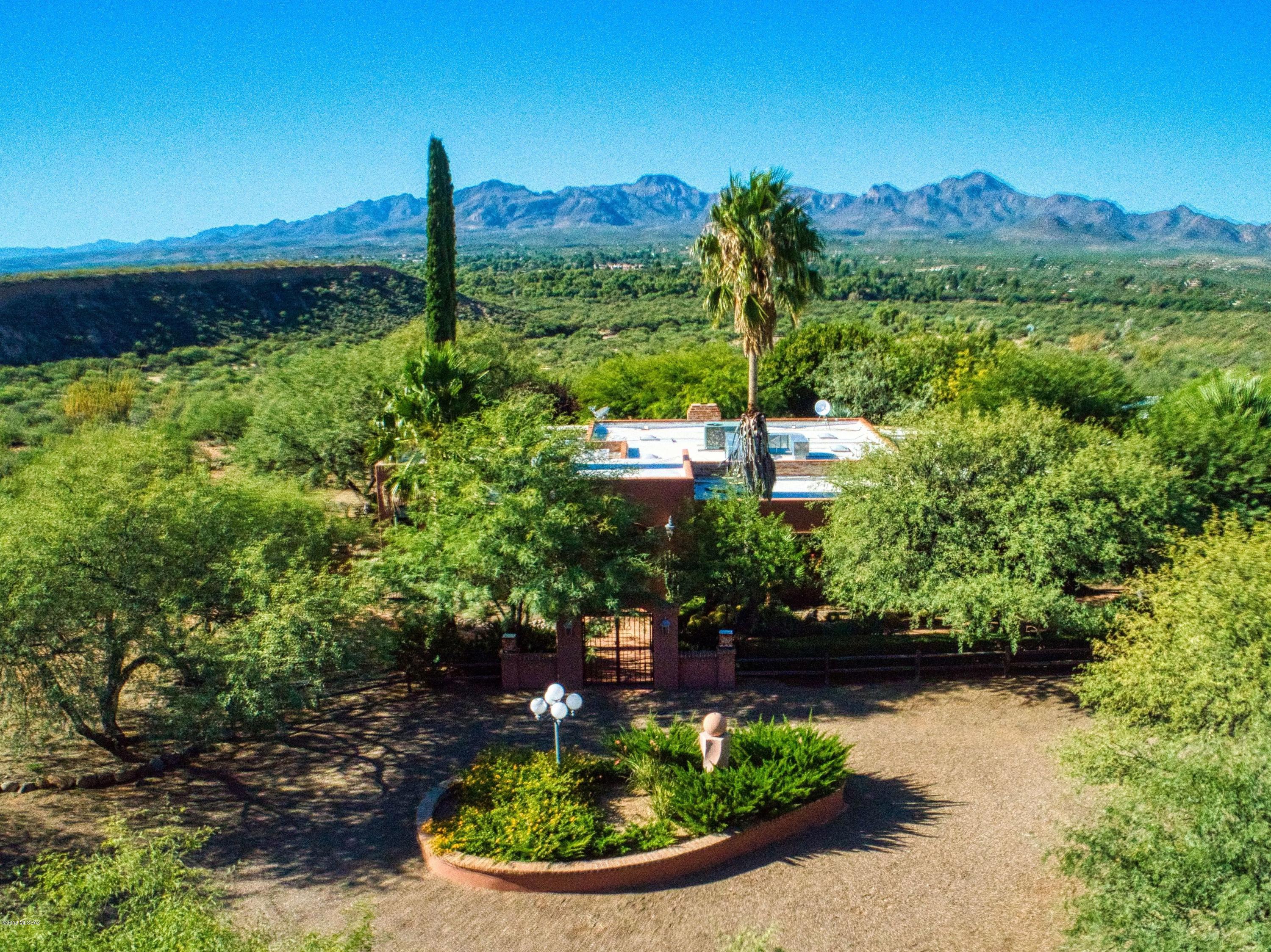 Outstanding views in every direction combined with elegance and function describe this 3,998-square-foot, 3-bedroom/3-bathroom estate situated on a 20-acre bluff overlooking the entire Santa Cruz Valley! Extensively remodeled, this breathtaking home has everything you would expect including lush grounds with pool and spa nestled among mature mesquite trees; a ramada looking down toward the Santa Cruz River Valley with the Tumacacori Mountains as a backdrop! The homesite has a masonry wall entry with wrought iron gates and a circular driveway with plenty of room for guest parking. Once inside you will enter an elegant foyer leading to a large family room. This room features ample windows overlooking the enclosed backyard and patio area, an outdoor shower, an outdoor shower, porcelain tile floors and a wood-burning fireplace for those chilly desert nights. The kitchen was meticulously professionally designed and is complete in every respect including lots of counter space and storage, yet all of the appliances you need are close at hand. The large primary bedroom is warm and inviting and has a comfortable sitting area as well as a large primary bath with soaking tub and separate shower. This home exudes the Tubac lifestyle!