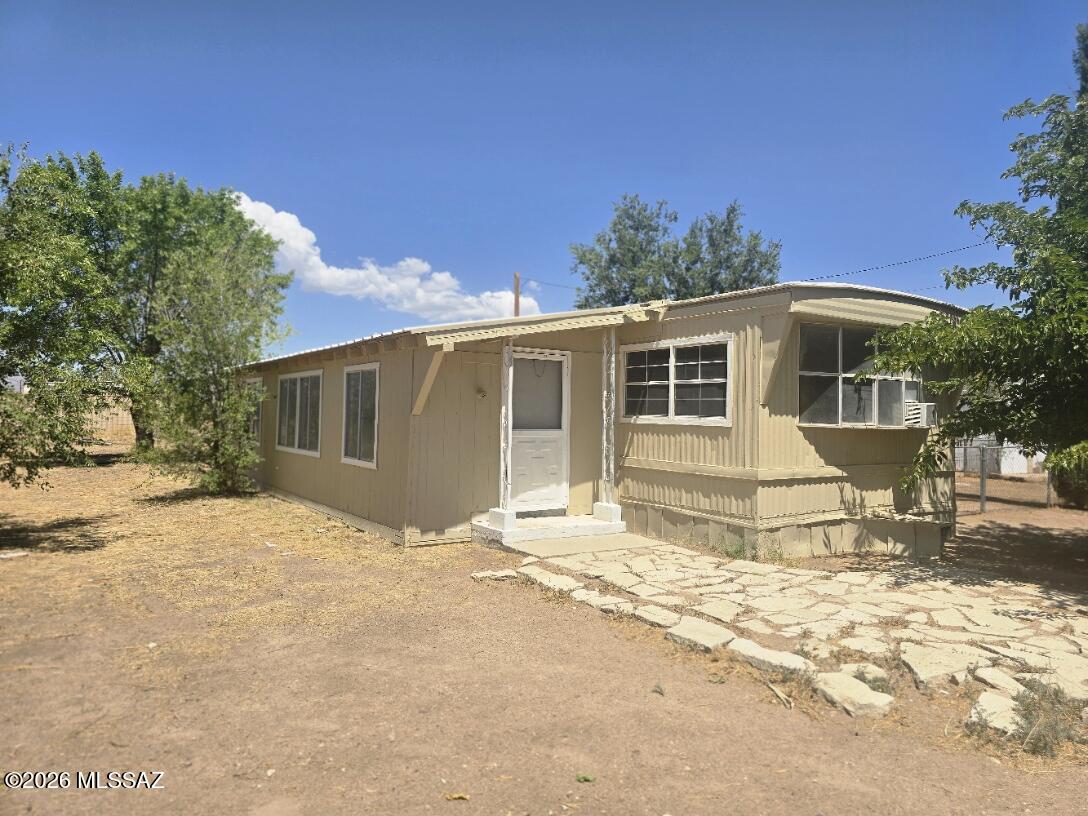 Great Country location with paved road access. Older manufactured home in the country on 1.99 Acres. 2 bedroom and 1 3/4 bathrooms. Home has a large add on that has a extra living room and den/office or 3rd bedroom space and storage area.  Mature trees and natural vegetation . Property has a garage/work shop plus 2 smaller storage sheds.