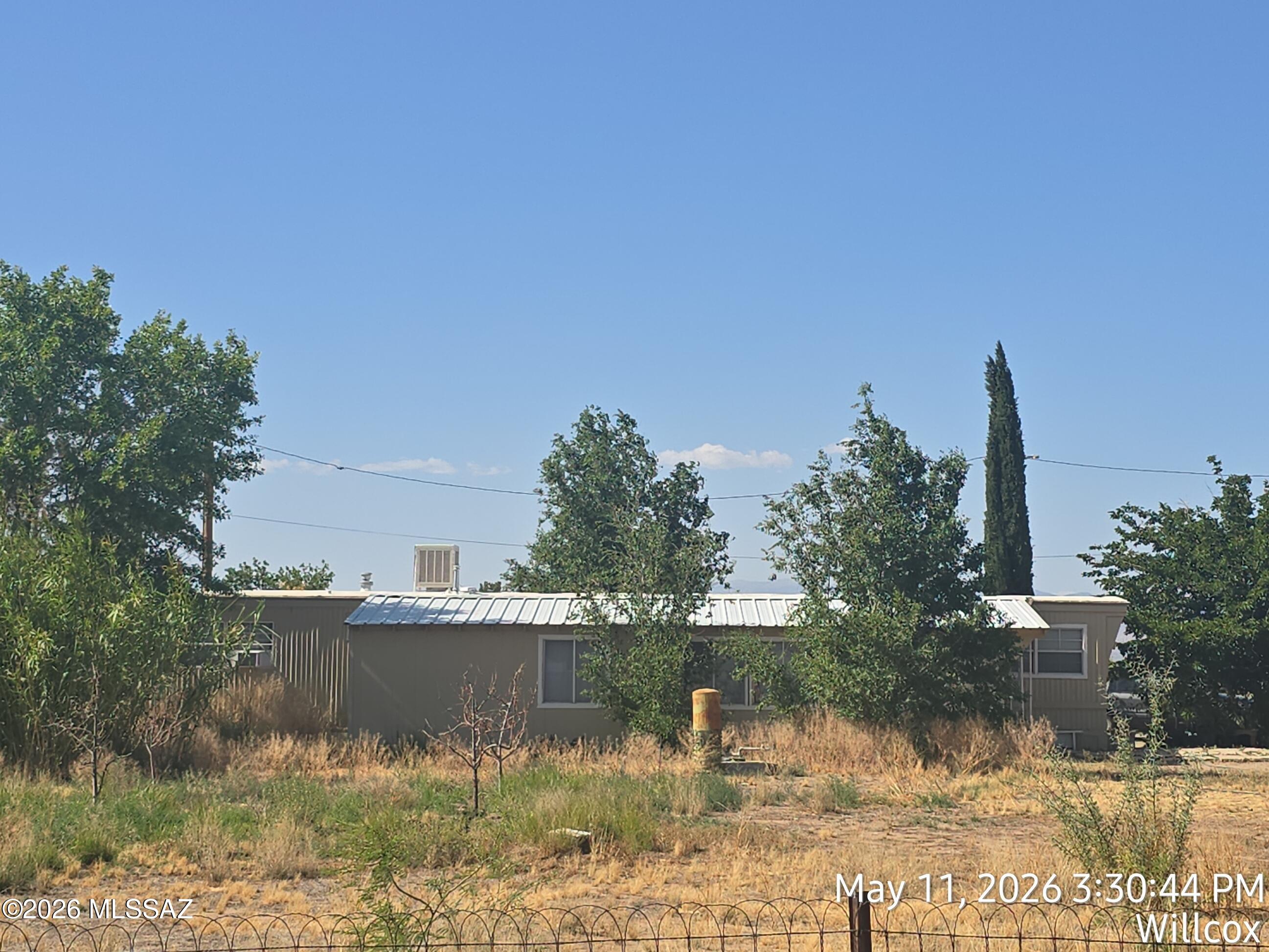 Great Country location with paved road access. Older manufactured home in the country on 1.99 Acres. 2 bedroom and 1 3/4 bathrooms. Home has a large add on that has a extra living room and den/office or 3rd bedroom space and storage area.  Mature trees and natural vegetation . Property has a garage/work shop plus 2 smaller storage sheds.
