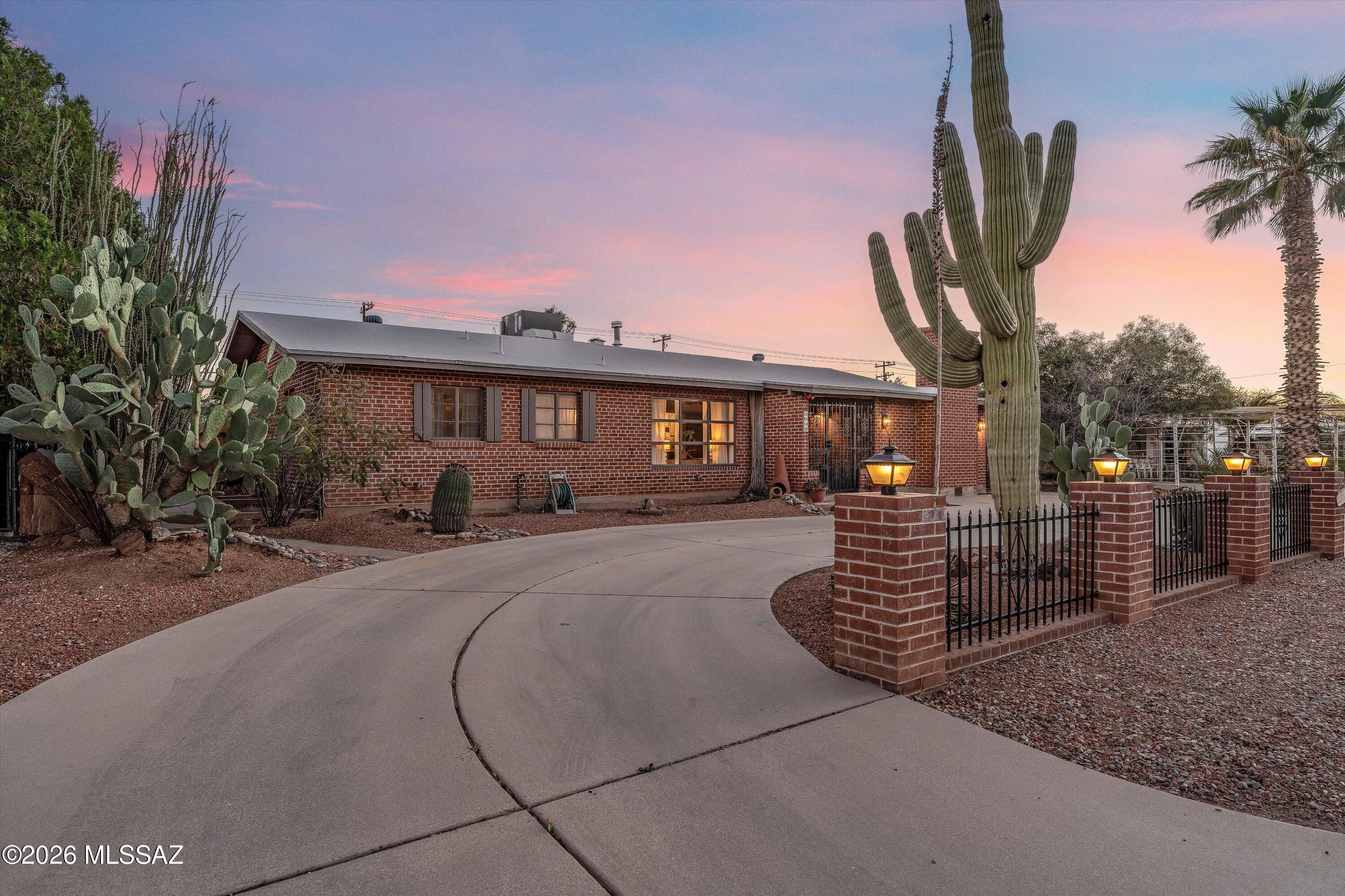 Tucked into the heart of the Samos neighborhood, this mid-century home is designed for the way Tucson loves to live. Summers by the saltwater pool under the covered patio, cooler evenings around the brick and flagstone fireplace. With multiple entertaining spaces, a built-in bar, warm natural light, and a lush backyard, the home balances energy and calm in all the right ways. Large windows bring in beautiful light for reading, plants, and everyday living. The .26-acre lot offers privacy, mature citrus trees, alley access, and room to expand for a shop or ADU. Updates include newer HVAC, plumbing supply lines, upgraded electrical panel, and remodeled baths. Near Mitchell Park, Campbell Ave's ''Restaurant Row,'' Mountain Ave for Cat Tran/The Loop, Banner, and the U of A.