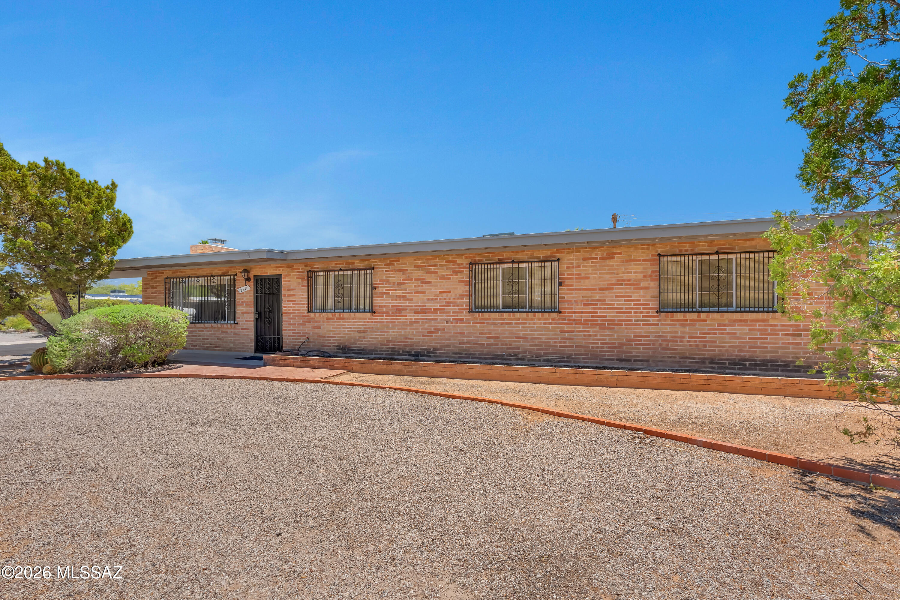 This solidly brick-constructed over 2000 sq.ft. corner-lot house shows charm, quality and character . 4 Bedrooms , 2 skylight-bright full bathrooms, separate dining room and a workshop.. Breakfast bar and a spacious living room with wood-burning fireplace  Sitting on an approximately quarter of an acre beautifully landscaped grounds. An inviting large sparkling pool and a diving springboard. Extended covered patio ideal for dining and entertainment. Meticulously built back-yard shed ( unfinished interior paint) can be used for storage , studio or a second workshop.  Appliances included.
Centrally located ,  close access to schools, culture venues, medical centers , shops and restaurants  and easy drive to Sabino Canyon .Put your own personal touch to this house and make it your own.