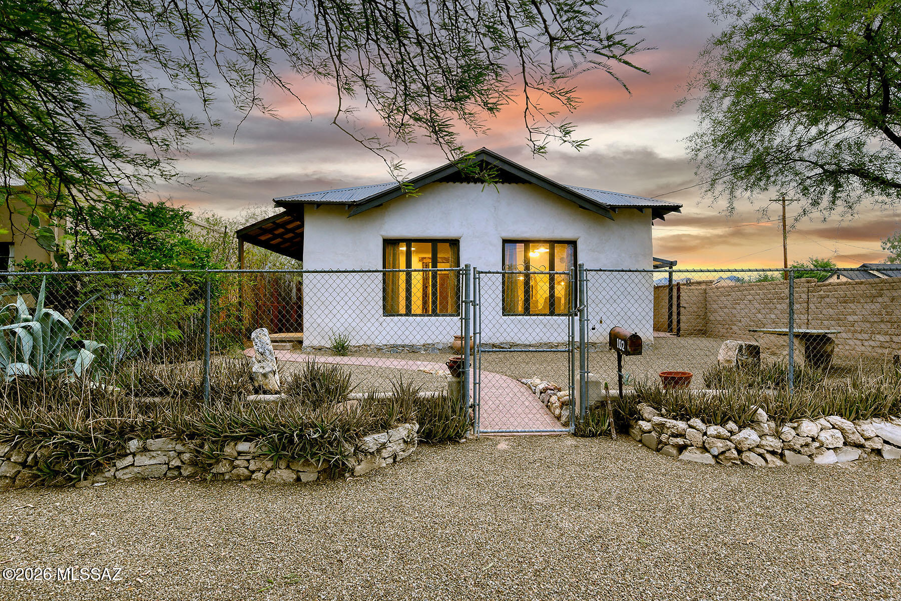 If you've been searching for an authentic 1915 mud adobe home, this is a rare opportunity. Rich in character & craftsmanship, the home features 2-foot-thick adobe walls, 12-foot painted wood ceilings, handmade lintels & thresholds, painted pine floors, Saltillo tile, graceful archways, & traditional niches thruout.
The beautifully restored eat-in kitchen opens to a functional mud room, while the separate familyrm is accented by a wood-burning corner fp. The home offers 3 bedrms & 1 bathrm w/ a Mexican tile tub  shower surround, along w/a light-filled Arizona rm that provides additional living space. Situated on a large lot w/a huge backyard,  a durable metal roof & a manual metal entry gate and adobe exterior walls, completing this exceptional example of Tucson's early adobe architecture.