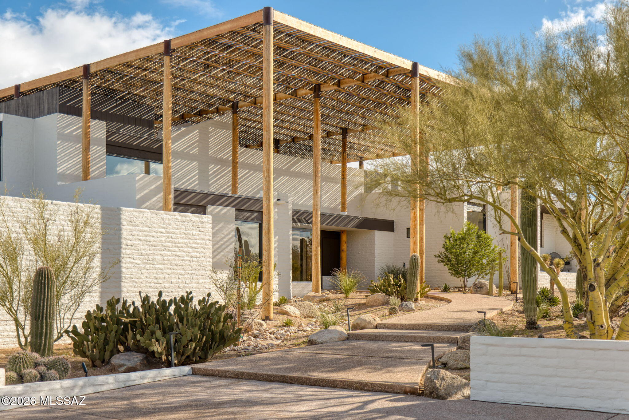 Set across more than six pristine protected acres in the Catalina Foothills, with uninterrupted 360-degree mountain, desert, and city vistas, the Ramada House stands as a singular offering -- iconic, private, and now permanently protected. Originally conceived by renowned architect Judith Chafee in 1975, this is widely regarded as her masterpiece and one of the most significant examples of Desert Modernism in the American Southwest.

Listed on the National Register of Historic Places and internationally studied, the Ramada House is more than a residence -- it is a landmark of American architectural history, reintroduced in its strongest and most compelling form.  Qualified for reduced property taxes.  

Now fully restored and sensitively renovated by designer Casey W. Smith, the residence now stands in its most resolved architectural form -- its architectural integrity preserved, its systems and finishes thoughtfully elevated for modern living. Every refinement honors Chafee's original intent: disciplined geometry, filtered light, and architecture shaped by climate rather than trend.

A monumental timber ramada -- Chafee's defining gesture -- spans the residence, casting shifting patterns of light and shadow while creating a powerful thermal canopy above. Below, the home unfolds in layered planes that step naturally with the terrain. Terraces, courtyards, and transitional spaces dissolve the boundary between interior and desert, reinforcing the seamless integration of structure and landscape.

Concrete masonry construction, mortar-washed surfaces, and exposed structural timber speak to Chafee's rigorous modernism, while refined updates enhance livability without compromising architectural authenticity. The residence is also equipped with state-of-the-art twin gas-powered backup generators. Public and private spaces are thoughtfully layered, creating both intimate retreat and dramatic entertaining environments beneath the filtered desert light. 

The Ramada House has been featured in the MOMA traveling exhibit: "Judith Chafee: Framing the Desert" highlighting her contributions to regional, sustainable architecture, along with her international recognition. The Ramada House has been featured and studied on Smithsonian-affiliated architectural tours of the American Southwest.

Located within the most coveted enclave of the Catalina Foothills -- the storied "Old Foothills" -- this offering represents a rare convergence of architectural significance, land preservation, and enduring desert beauty.