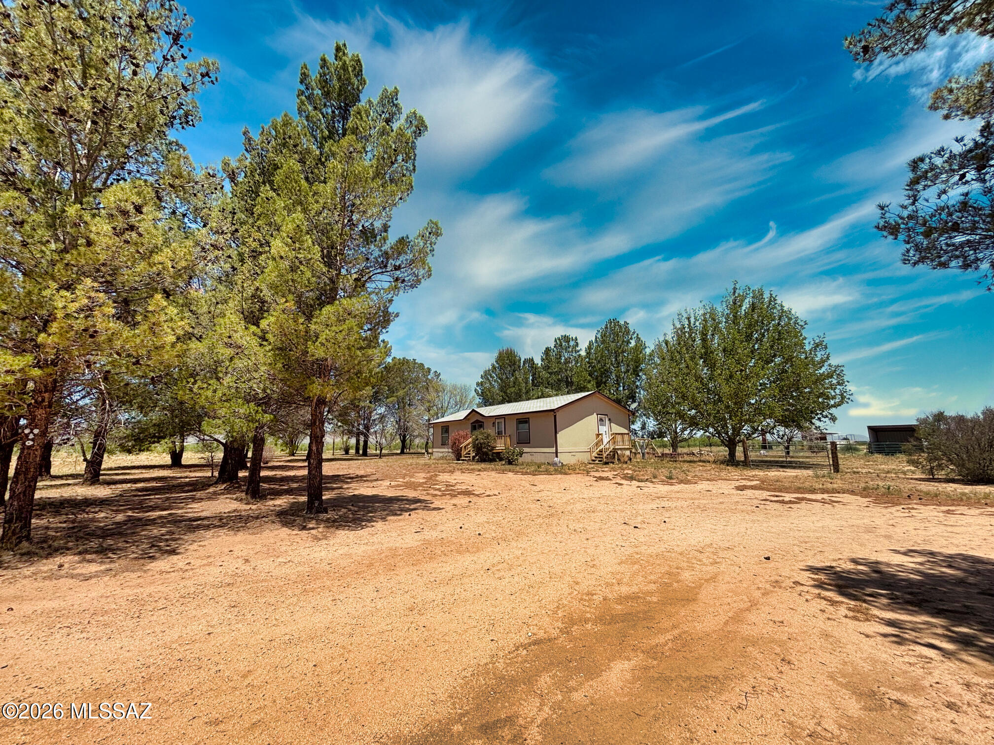 Bring your horses to this lovely 5 acre paradise with lots of trees, turnout for horses plus a barn and horse shade/shelters. Ride out right from the home. Great Stronghold Mountain views. Long driveway. Home sits way back on the lot with large trees out front, on the West and North sides of the home.  Property is also fenced and gated. The home is serviced by a Private well.  Large covered and screened back porch which faces North, so it's always shady. Storage sheds. Home is well maintained. Move in ready. Split bedroom floor plan. Walk in Closets in every bedroom! Full RV hookups. 2 septic systems. Has Highly Desired RU-4 Zoning. Home Warranty good through 5/5/2028.