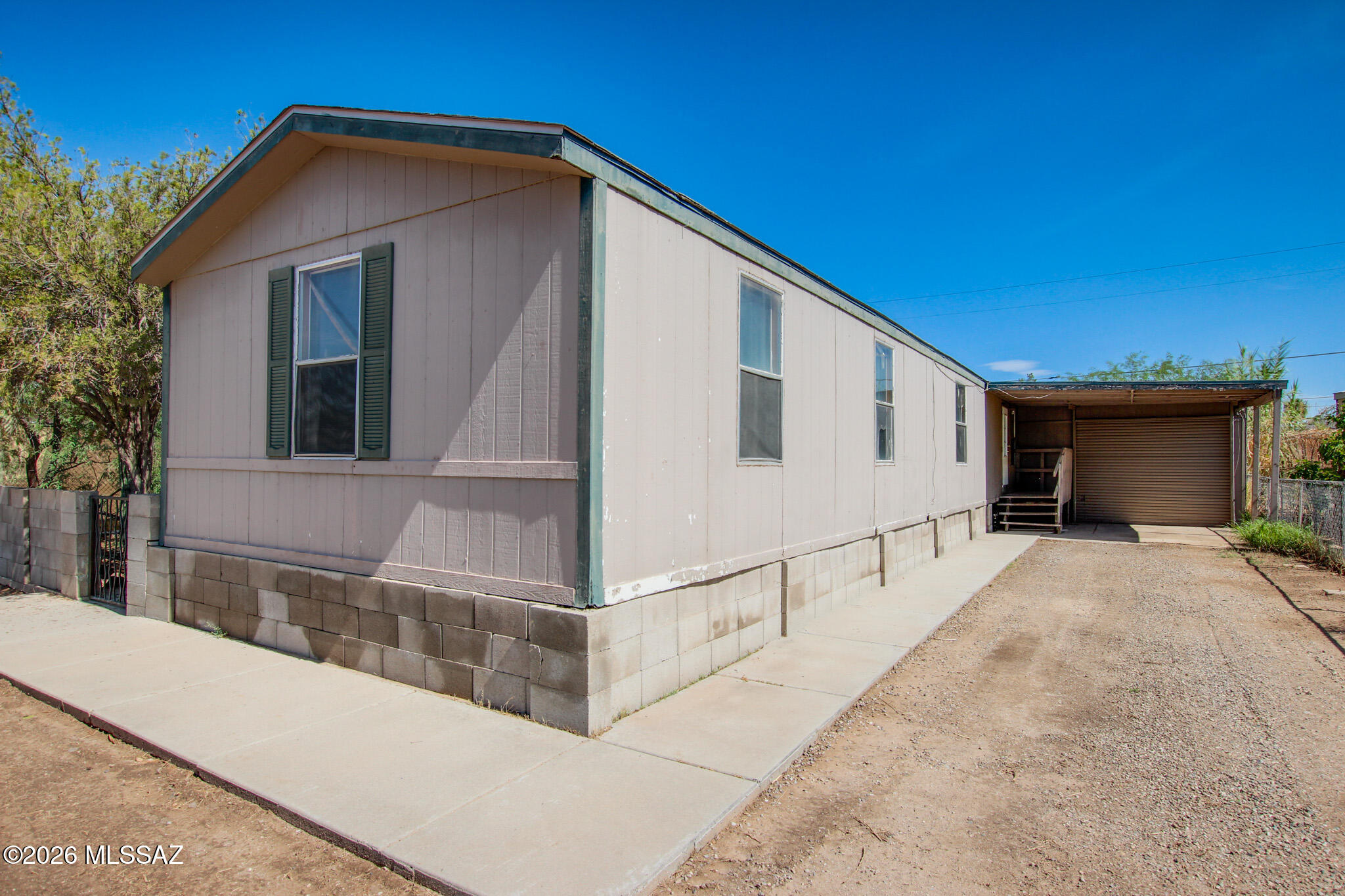 Investor & handyman special on OWNED land - no lot rent, NO HOA, and on SEWER (no septic!). This 3 bed / 2 bath manufactured home offers 1,605 sqft with a great room floor plan, kitchen island, and split bedrooms. Fully fenced lot with block wall, gated entry, garage AND covered carport. Newer AC. Home needs cosmetic updates throughout - flooring, paint, and finish work - bring your vision and build instant equity. Renovated comps nearby support $200K+ after updates, making the spread work for flippers, landlords, or owner-occupants ready for sweat equity. Fee-simple title, affixed home, Flowing Wells schools, minutes to I-10, shopping, and dining. Sold strictly AS-IS. Cash or hard money only. Priced to move - this much upside doesn't last. Bring all offers!