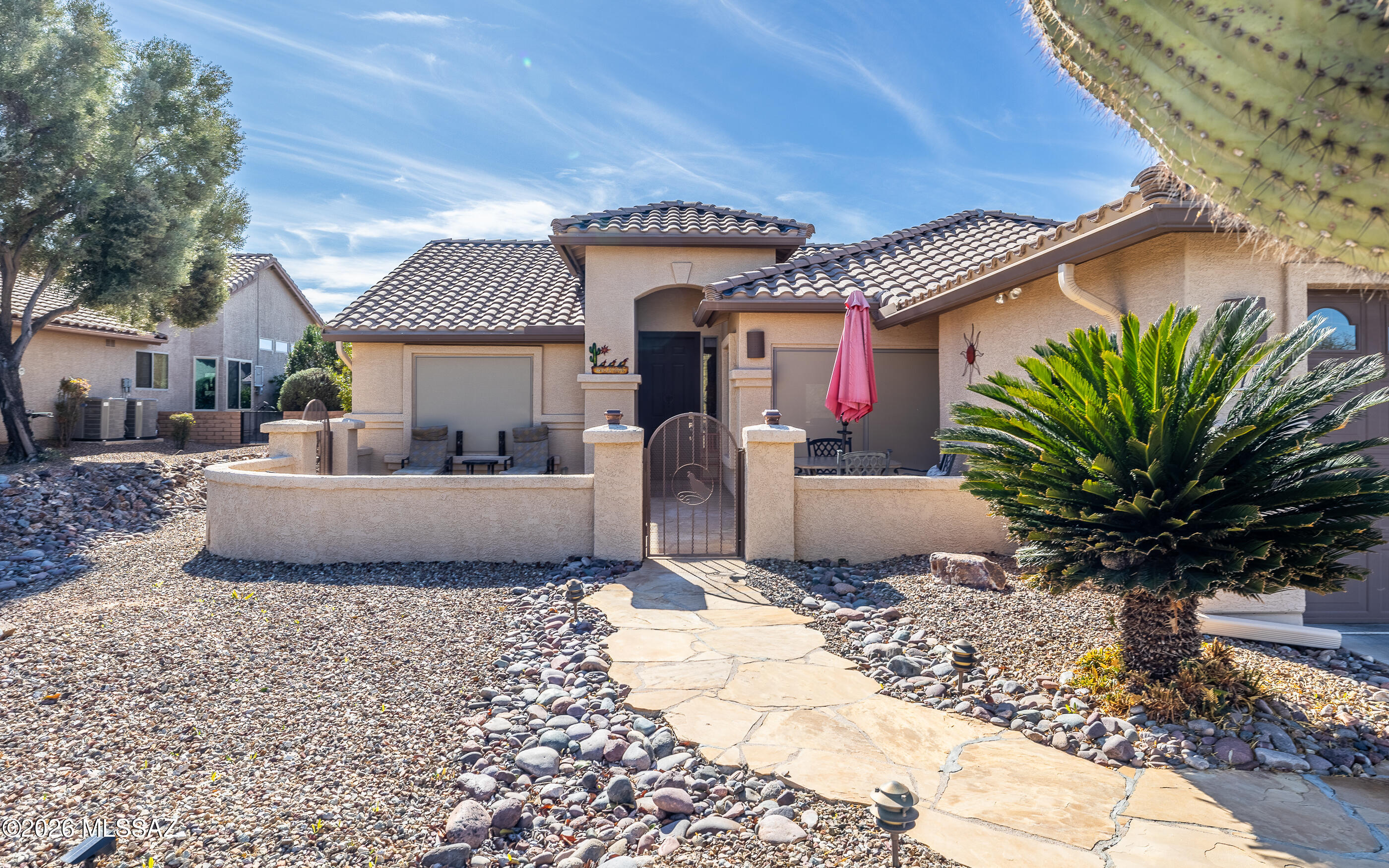 This popular Laredo model within walking distance to amenities, features bedroom, den, kitchen and garage extensions. Expansive patios, with beautiful views and built in fireplace + grill, on almost a 1/4 acre lot on a wash, providing privacy and Mt views. Impeccable remodel with a neutral palette throughout. Wood-look ceramic tiling. Extended kitchen with island & breakfast area features leathered granite counters, cherry soft-close cabinets, breakfast area w/sliding patio door to a gated patio with Mountain views. Solar screens on front for privacy. Owners suite includes patio slider and master closet system. Roomy dining and great room for entertaining, or relaxing. Washer and Dryer do not convey. This spectacular Gated Community features newlly built Canyon Club, with Bistro, indoor/outdoor pools, fitness center, spa services, Golf 27 holes, tennis, pickleball 32 courts, a libray and interest based clubs.