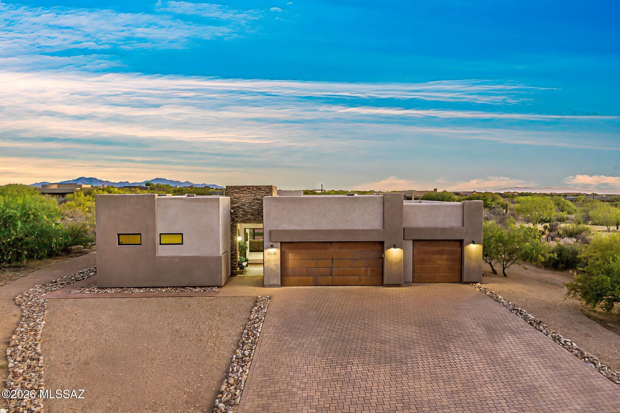 Exquisite custom home built in 2021 within the highly sought-after gated community of Coyote Creek, a premier enclave nestled in the pristine Rincon Valley. Nestled on an  expansive 1.17-acre private homesite. This exceptional modern residence offers the perfect balance of sophistication, and modern contemporary architecture.  A custom solid-metal entry door with integrated glass creates a striking first impression and sets the tone for the thoughtfully curated interiors beyond. Inside, the thoughtfully designed floor plan is highlighted by soaring ceilings, warm neutral tile flooring, abundant natural light, and an open-concept design ideal for both everyday living and entertaining. At the heart of the home, the kitchen blends beauty and functionality with a dramatic quartz island, premium stainless steel appliances, stylish tile backsplash, and crisp white cabinetry accented with glass details. Sleek black designer sconces above the island add a sophisticated touch, while the oversized walk-in pantry provides exceptional storage and organization.

The kitchen flows seamlessly into the expansive great room, where dramatic metal folding glass doors dissolve the boundary between indoors and out, opening to the covered patio and creating the ultimate Arizona indoor-outdoor lifestyle experience.
Designed with privacy and comfort in mind, the split-bedroom floor plan offers ideal separation between the owner's suite and guest spaces. The spacious primary retreat features recessed lighting, a clerestory window for soft natural light, and a spa-inspired ensuite complete with quartz countertops, dual vanities, a soaking tub, and a large walk-in shower wrapped in floor-to-ceiling tile.
Additional highlights include abundant storage throughout and an oversized 3-car garage offering flexibility for vehicles, hobbies, or workshop space.
Life in Coyote Creek offers a rare connection to the Sonoran Desert with an unmatched sense of space and serenity. Residents enjoy access to state-of-the-art equestrian facilities, pickleball, tennis and basketball courts, scenic horse and walking trails, and the benefit of the highly regarded Vail School District.
If you are seeking refined desert living within one of Southern Arizona's most distinctive gated communities, this exceptional home delivers.