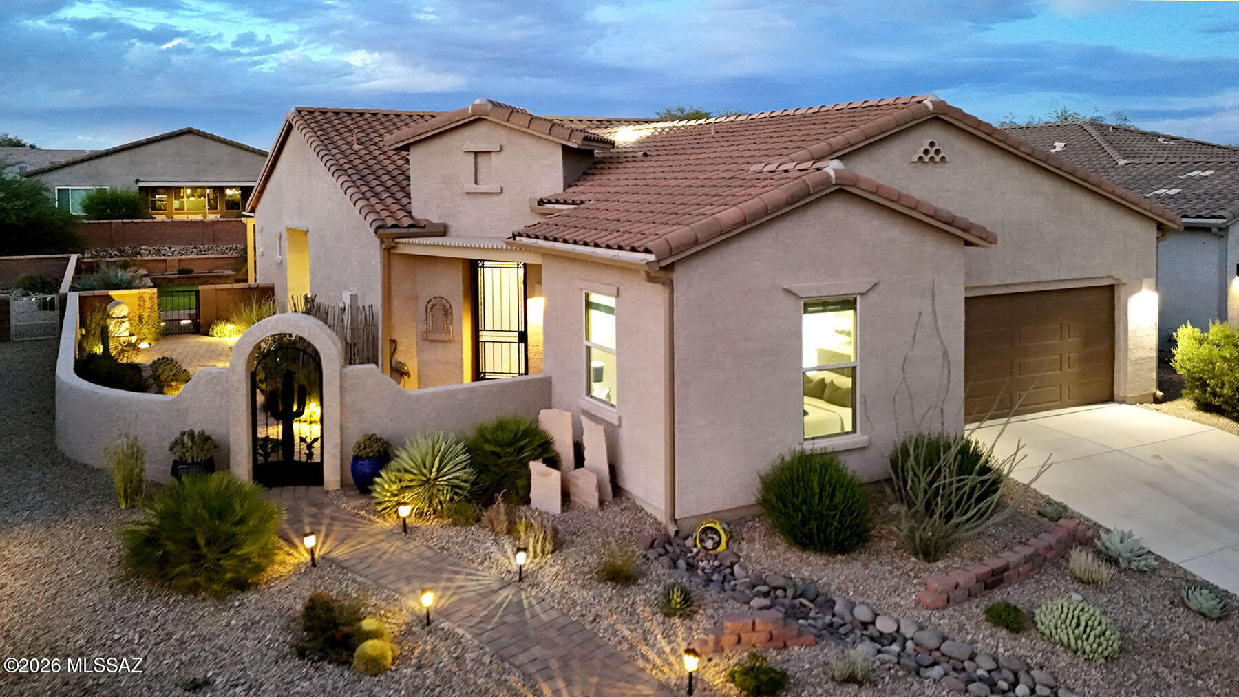 This is the home you pictured when you decided to move somewhere extraordinary. Modern. Light. Alive with possibility. Every morning a gift, every evening a reason to linger. A backyard that rivals any resort. A primary suite that feels like a five-star escape. And all of it bathed in the incomparable golden light of Southern Arizona.  Step inside and be immediately embraced by soaring ceilings and a cascade of natural light that floods every corner. Thoughtfully curated upgrades and modern finishes layer seamlessly throughout -- this is a home that has been loved and elevated with intention, where every detail feels considered and every surface sparkling clean and bright. The open-concept layout invites easy connection between spaces, between people, and between indoors and the stunning world just beyond the glass.
The backyard here is not an afterthought -- it is the main event. Lush green turf stretches underfoot, anchoring a landscape that is both verdant and effortlessly beautiful. Multiple gathering spaces invite you to choose your mood:  the sheltered pergola for languid dinner parties under the stars; a quiet corner tucked among the plantings for an afternoon with a book and something chilled. Thoughtfully designed and impeccably executed, these outdoor rooms expand your living space exponentially.  The primary suite is not just a bedroom -- it is a world unto itself. Wake slowly and pad to your own private coffee bar, steam the perfect cup, and take it to your secluded patio where the morning air is still cool and the light is soft and golden. A beautifully tiled walk-in shower sets the tone for the day ahead. Come evening, the suite transforms again -- uncork a bottle from your private wine bar, settle onto the patio, and watch the sky do what only Arizona skies can do. 
Guests arrive and immediately feel at home in their own beautifully appointed retreat -- a lovely guest bedroom and well-designed bath that offer privacy and comfort well beyond the expected. The open-concept bonus room flows naturally from the main living areas, equally at home as a sophisticated home office, creative studio, or flexible gathering space that simply adapts to your life. This is where your next journey begins.  Welcome home!