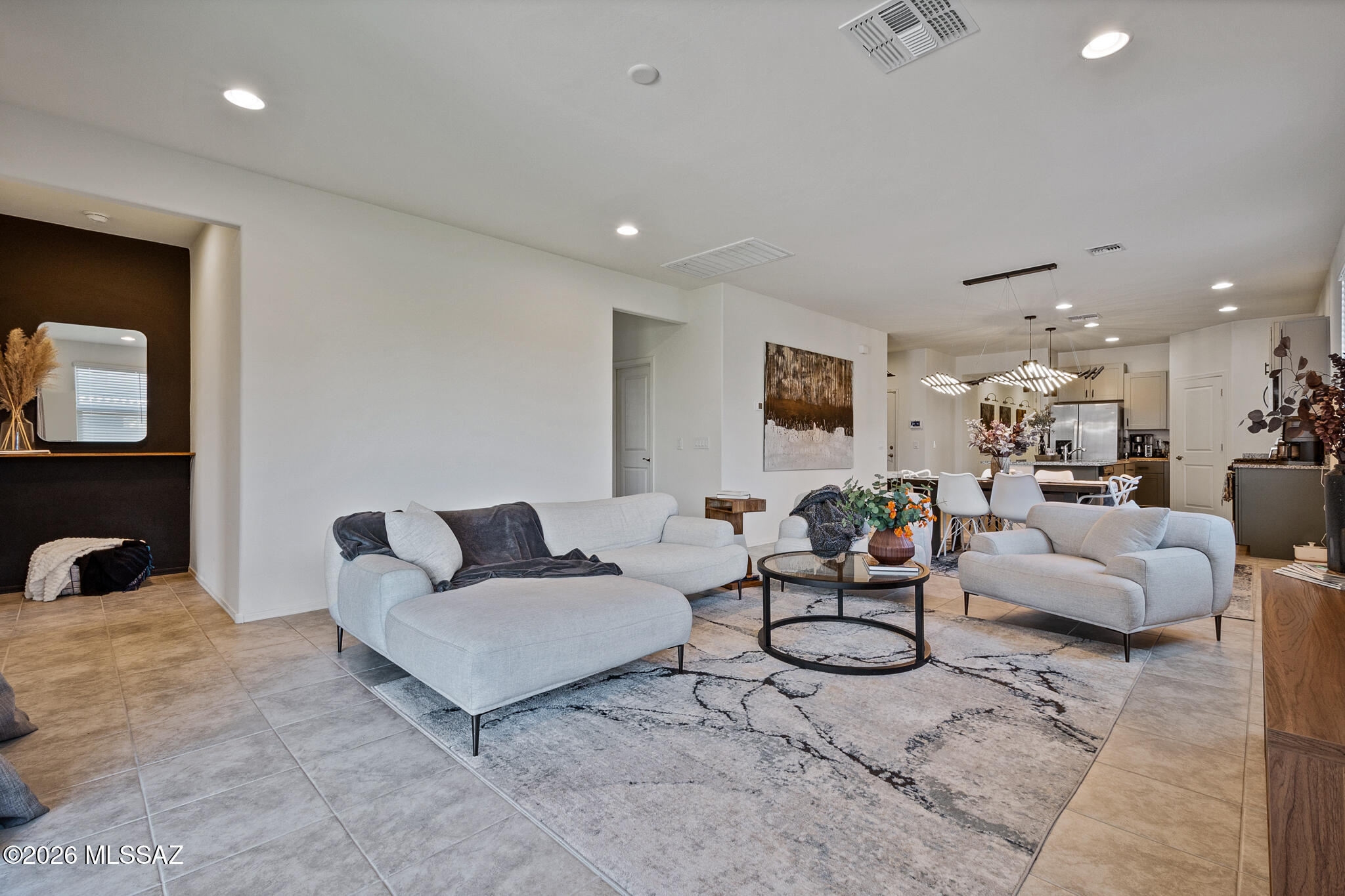 This modern home sits on a generously sized corner lot and is available fully furnished inside and out! The flexible floor plan features 4 bedrooms, including 2 with their own ensuite, and 2 living spaces. The kitchen features a large island, stainless steel appliances, and gorgeous 2 tone cabinets. All plumbing and light fixtures have been upgraded presenting a clean contemporary feel. The large primary has personalized touches including a barn door, floating cabinet, and custom painted wall. Outside features a covered patio, a large turf area, and an extended paver seating area, complete with fire pit and dining set. The spray foam insulation provides excellent energy efficiency. Situated in an ideal location in the growing Rancho Marana neighborhood, commuting and shopping is a breeze! Garage gym and all equipment, including pilates machine are available on a separate bill of sale.