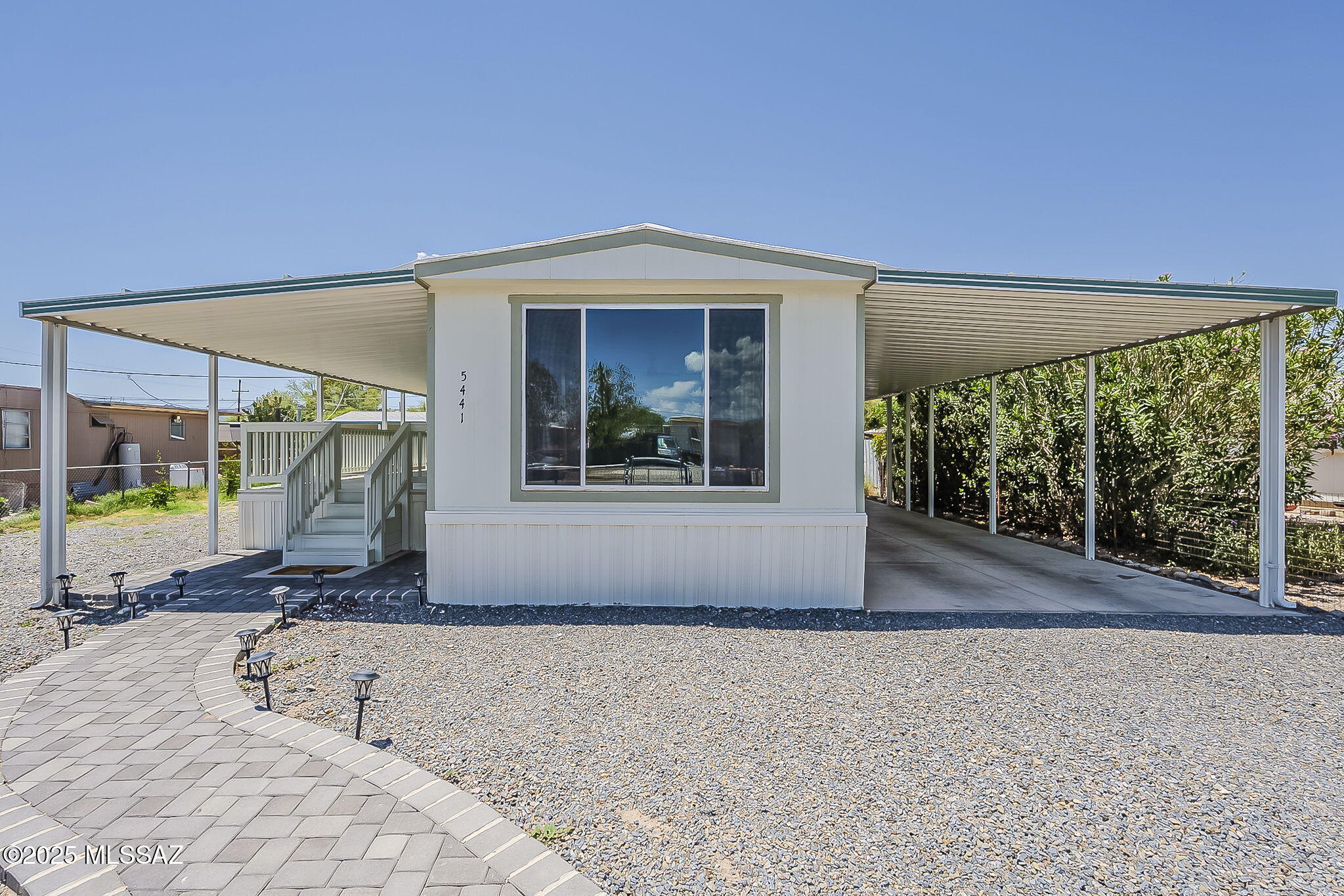 Discover this charming 2-bedroom, 1-bathroom home featuring 924 sf of thoughtfully designed living space. The property showcases luxury vinyl tile flooring throughout, creating a seamless and modern aesthetic. The heart of the home features a beautifully remodeled Davis Kitchen equipped with an electric range and stainless ensemble of appliances, plenty of cupboard space, pantry and views of the Catalinas. Front loading washer and dryer also included! Find peace and relaxation from your extended covered patio with mountain views. The attached 2-car carport provides excellent convenience, while recreational vehicle parking is also allowed for adventure enthusiasts. Additional highlights include a spacious 12x20 storage unit, 2 year old HVAC, fenced yard, swing-open front gate and no HOA!