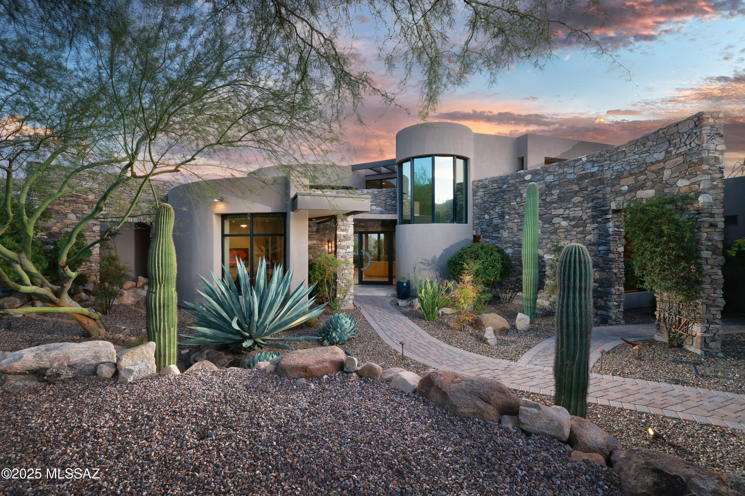 Timeless Contemporary Estate in Stone Canyon: Embrace unparalleled luxury and breathtaking desert landscapes in this exquisite 3-bedroom, 5-bathroom contemporary residence, beautifully situated on a 1.02-acre lot within the prestigious guard-gated Stone Canyon community. Designed by renowned Tucson architect Kevin Howard and built in 2008, this 4,453 sq ft home offers a lifestyle of sophistication and serenity amidst dramatic rock outcroppings and panoramic views of the Catalina Mountains and close up views of the saguaro studded Tortolita Mountains. This exceptional property offers a rare opportunity to own a meticulously designed and flawlessly executed contemporary estate in one of Oro Valley's most sought-after communities, providing a lifestyle of ultimate luxury and natural beauty.