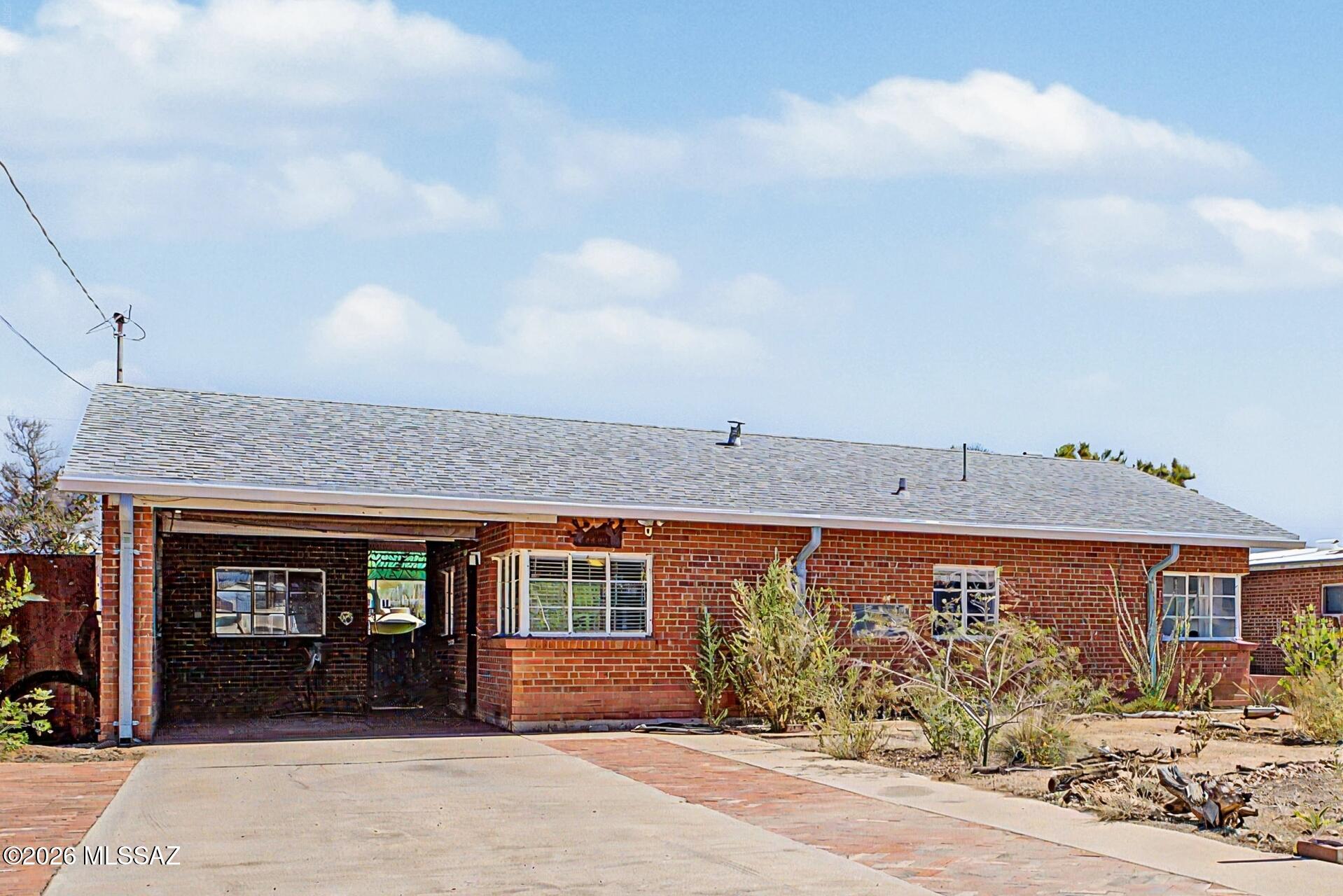 Discover the perfect blend of character, modern upgrades, and location in this beautifully updated solid brick Tucson home, ideally situated just 11 minutes from the University of Arizona. Whether you're searching for a primary residence, student housing, vacation home, Airbnb opportunity, or a high-demand Tucson investment property, this move-in-ready home offers exceptional value in one of Southern Arizona's most sought-after locations.

From the moment you arrive, you'll appreciate the stunning curb appeal highlighted by custom wrought-iron accents, mature desert landscaping, and a welcoming front entry that showcases the timeless appeal of authentic Tucson architecture. This charming 2-bedroom, 1-bathroom home has been thoughtfully updated while preserving its solid brick construction and enduring character.

Inside, you'll find a beautifully remodeled kitchen designed for both everyday living and entertaining. Features include luxurious quartz countertops, stainless steel appliances, a gas range, custom walnut floating shelves, modern fixtures, and ample workspace. The open and inviting layout creates a seamless flow between living spaces, while durable hard-surface flooring throughout provides easy maintenance and contemporary style.

The outdoor living spaces truly set this property apart. Enjoy Arizona's year-round sunshine in your private backyard oasis featuring a custom brick BBQ area, mature fruit trees, vibrant cactus gardens, and a hummingbird-friendly landscape designed to attract local wildlife. Whether hosting gatherings, relaxing after work, or enjoying peaceful mornings with coffee, this backyard offers endless possibilities.

One of the home's most valuable features is the rare RV parking and access. Double rear gates provide convenient entry for recreational vehicles, trailers, boats, or additional parking ideal for outdoor enthusiasts, travelers, or homeowners seeking additional utility and convenience.

Additional improvements include new gutters, an updated electrical panel, enhancing efficiency and providing peace of mind for future ownership. A 300 gallon water harvesting barrel for watering.