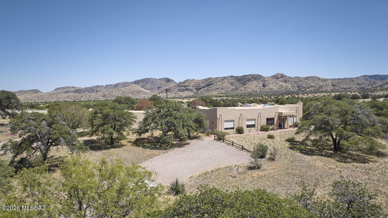 A refuge in the Chiricahua foothills, this 1999 architectural gem is 2800 sf on 47 acres in ranch country next to Sunglow Ranch former upscale resort. 2 BR, 2 BA w/10 foot beamed ceilings. Spacious kitchen, large dining area for entertaining, floors & all counters are Mexican tile, rolling security shutters, windows frame views of nearby hills & Chricahua peaks. Walled courtyard connects to 800 sf guest cottage w/kitchen & bath. Steel framing, concrete block & mud adobe walls, stucco elastomeric finish, rolled membrane roof. Private well, tankless water heater, FIOS, seller-owned solar panels. 50 miles to Willcox, Douglas shopping, forest hiking trails just up Turkey Creek. Astronomers will love the dark skies. The 47 acres are protected by a conservation easement. Furnishings available.