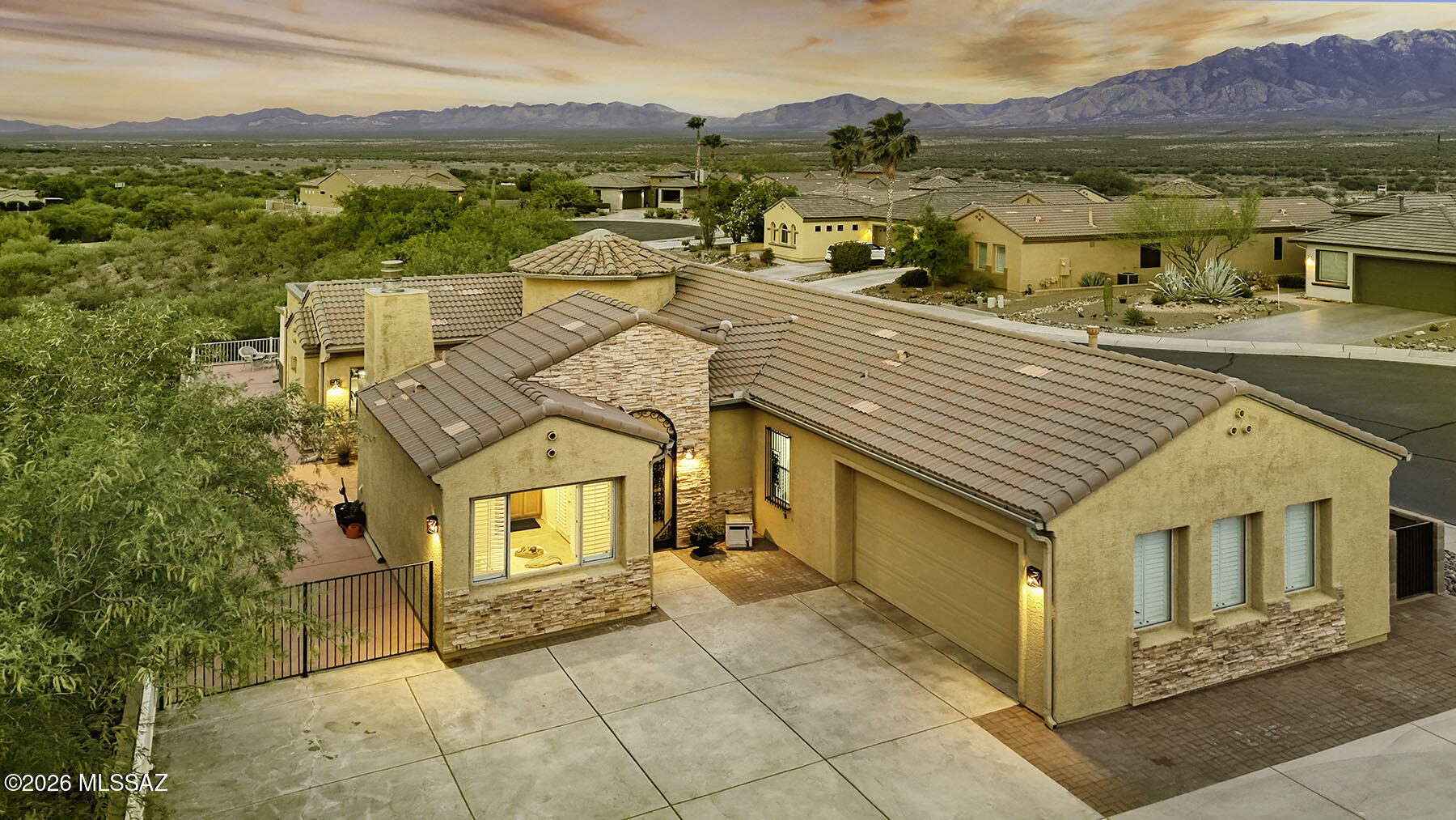 From the moment you arrive, this home makes a statement. A generous front courtyard  unfolds before you, anchored by a roaring fireplace that draws family and friends into easy conversation under a canopy of stars. This is not merely an entry; it is the first act of a home designed entirely around the art of living well. 
The wraparound patio is nothing short of a masterclass in outdoor design. Thoughtfully configured to accommodate both grand celebrations and quiet, contemplative evenings, it transitions effortlessly from cocktail hour to starlit dinner. Sitting high on a hill, it captures views of the golf course from the side patio and the mountain vistas beyond from the back patio, with absolute privacy for your outdoor living experience!  Step inside and the home opens up with soaring ceilings that flood every room with light and a sense of occasion. The living area, anchored by its own fireplace and dressed in classic plantation shutters, frames both the front and rear patios in a single glance -- a seamless conversation between indoors and out. The adjacent dining area and breakfast bar invite everything from a lazy Sunday morning to an elegant evening with friends.
The flexibility of this floor plan is extraordinary. Two generous bedrooms are complemented by a versatile den that adapts effortlessly to your lifestyle -- a media room, his-and-her offices, a craft studio, or the perfect retreat for guest overflow. Whatever your vision, this home has a space for it.
And then there is the casita. Nestled off the front courtyard with its own sense of privacy and charm, it offers guests a gracious sanctuary all their own -- a home within a home.
For those temperate Arizona evenings, the stunning Arizona Room beckons. Overlooking the golf course and framed by sweeping mountain vistas, it is a space that makes you forget the rest of the world exists.
Beyond the walls, a resort-style community awaits -- recreation centers, championship golf, and some of the most breathtaking views the Sonoran Desert has to offer. This is not just a home. This is a life, beautifully lived!