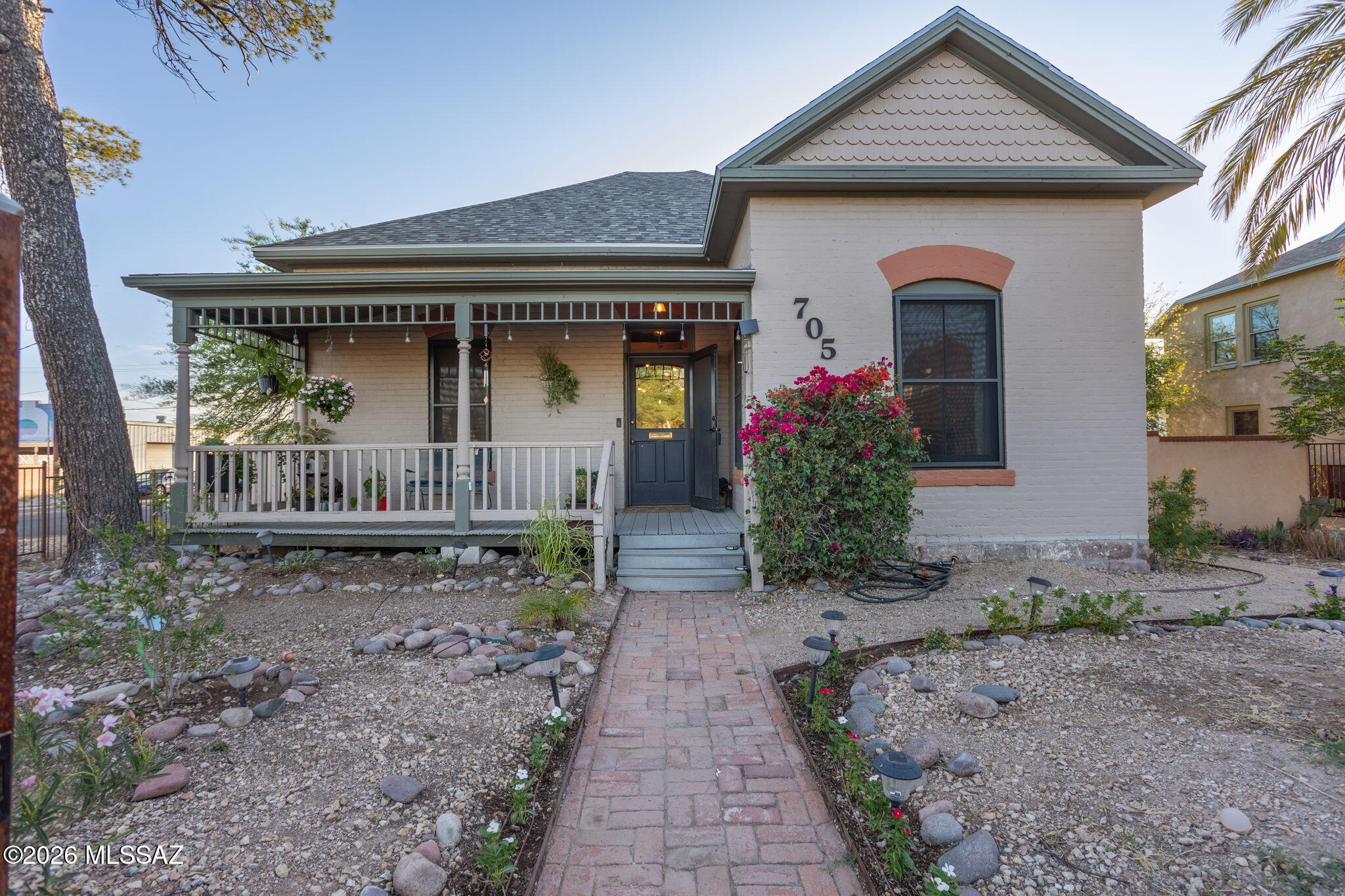 Welcome to your dream home in Tucson's West University Historic Neighborhood. 3 bedroom 2 bath with bonus room easily converted to 4th bedroom. High ceilings, exposed ductwork and industrial lighting blend modern living and historic charm. Enjoy more than 2,000sf of private walled-in backyard space complete with a paved patio and synthetic grass for plenty of activities. Original hardwood floors throughout, updated bathrooms, large windows and new carpet in great room.  Primary bedroom has fireplace and large bathroom w/ walk-in shower and soaking tub.  Located 1 mile from the UofA campus, blocks from 4th Avenue, & Downtown. Bosch refrigerator, large GE washer/dryer, farm sink, security screens, large front porch, mature trees, completely fenced in front and back. City living at its best!