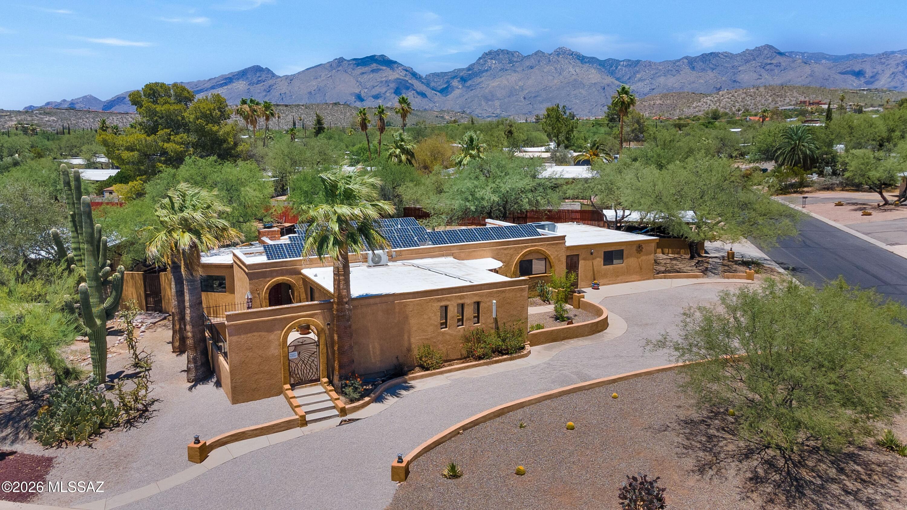Discover a residence where timeless Southwestern architecture meets effortless modern living. Privately situated on an expansive corner homesite of more than one-third acre, this beautifully appointed 2,822-square-foot property offers exceptional versatility, thoughtful design, and the indoor-outdoor lifestyle that defines Tucson. 

At the heart of the home, gracious living spaces unfold with warmth and character. A classic beehive fireplace anchors the inviting family room, while a separate living room provides an elegant setting for entertaining or quiet relaxation. A dedicated den offers an ideal home office, library, or creative retreat. For collectors and connoisseurs, a temperature-controlled wine room adds a refined touch, while the generous laundry and pantry area (continued) delivers abundant storage without compromising style.

Designed to accommodate a variety of lifestyles, the home features four bedrooms and three baths, including a private casita (604 sq ft) with its own entrance. Complete with a comfortable living area, bedroom, bathroom, and kitchenette, this thoughtfully designed guest residence is ideal for extended family, visiting guests, live-in caregivers, or those seeking a private executive office or studio.

Beyond the interiors, the property transforms into a secluded desert sanctuary. Multiple patios and distinct outdoor living spaces invite everything from intimate morning coffee to memorable evenings beneath the Arizona sky. At the center, a sparkling swimming pool creates a true resort-inspired setting, surrounded by mature landscaping that enhances both beauty and privacy.

Modern conveniences complement the home's enduring appeal, including an owned solar system for outstanding energy efficiency, an oversized two-car carport equipped with a Tesla EV charger, and generous outdoor space rarely found in such a desirable location.

Perfectly positioned on Tucson's sought-after east side, the home enjoys convenient access to the area's premier amenities. Spend weekends exploring the scenic trails of Sabino Canyon, golfing at nearby championship courses, or enjoying the renowned restaurants, boutiques, and galleries of the Catalina Foothills. World-class healthcare, the University of Arizona, and Tucson's vibrant cultural offerings are all within easy reach, creating a lifestyle that is both relaxed and connected.

Rich in character, exceptionally flexible, and thoughtfully designed for the way people live today, this is a home that offers not simply a place to reside, but an opportunity to embrace the very best of Tucson living.