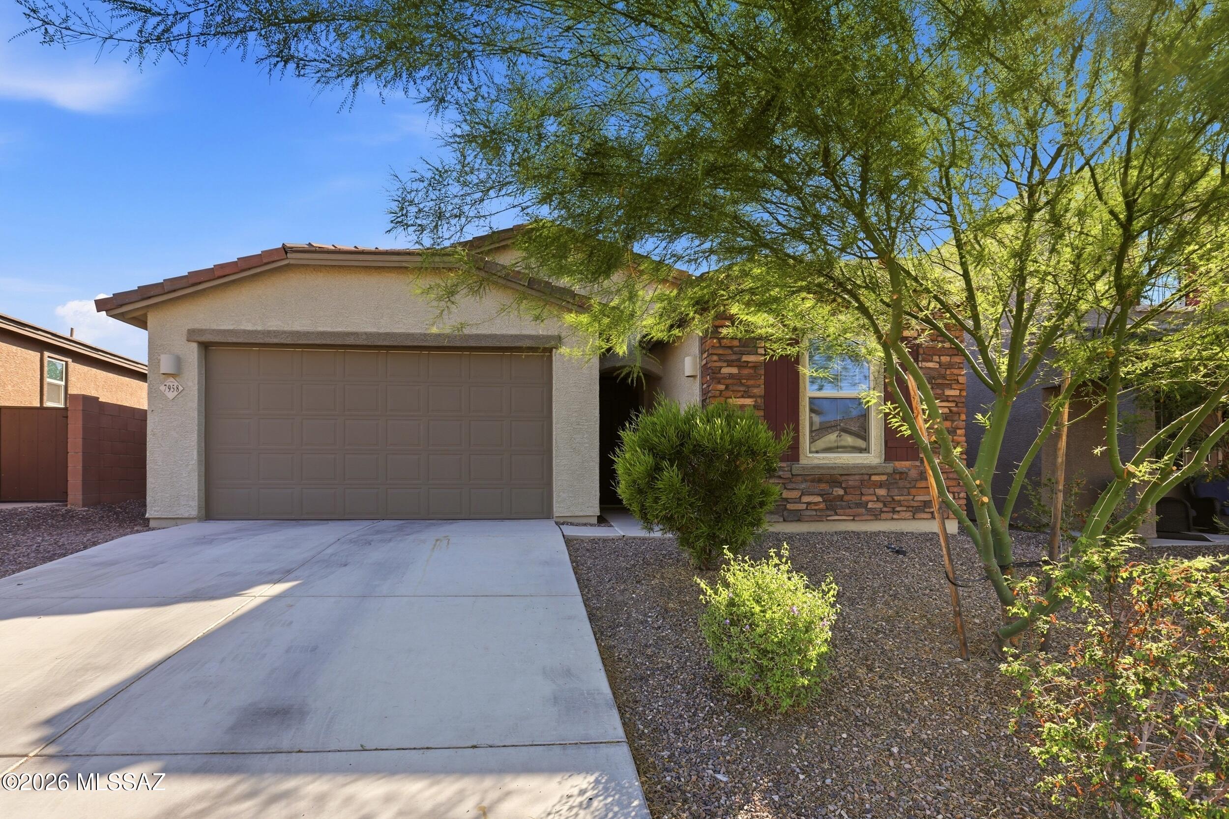 Welcome to this beautifully upgraded single-story home in the gated section of Rocking K, offering 5 bedrooms, 3 full bathrooms, and a thoughtfully designed layout. The open-concept kitchen features double ovens and flows seamlessly into the spacious living area with engineered wood flooring. Charming wallpaper accents add designer touches throughout. Step outside to a professionally landscaped, low-maintenance backyard with no rear neighbors, a natural wash behind the home, and stunning Arizona sunset views. Located in the award-winning Vail School District with easy access to Davis-Monthan Air Force Base and Raytheon, this home offers the perfect combination of privacy, convenience, and move-in-ready upgrades that set it apart from new construction.