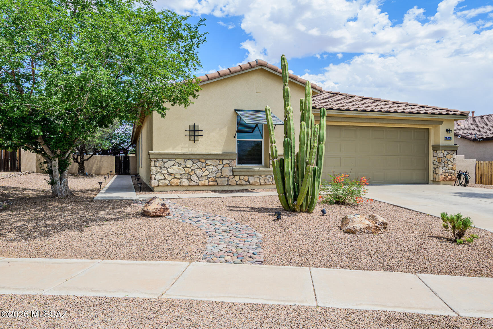 AWARD WINNING RANCHO SAHUARITA! Once in a while a listing comes on that feels like a HOME not just a house, this is the one! CUL DE SAC lot! Lots of natural light. Mountain VIEWS! Impeccably kept single story 1,861 sq ft, 3 bed, 2 bath + DEN/OFFICE or guest room. 20 inch tile throughout with carpet in bedrooms only. Freshly painted inside and out. Entertainers dream kitchen with black appliance suite and kitchen island. Great Room Concept. Split floor plan for extra privacy. Ample storage. All appliances convey. Central vac. Large Primary bedroom features large walk-in closet, garden tub, separate shower, and dual sinks. If that's not enough, step outside into your private backyard oasis that features mature trees, pavers, flagstone, fire pit, covered bar and movie screen. Community features a waterslide park, lake, pools, walking trails, clubhouse with fitness center, classes, events and so much more! Don't miss this. Schedule your showing today!