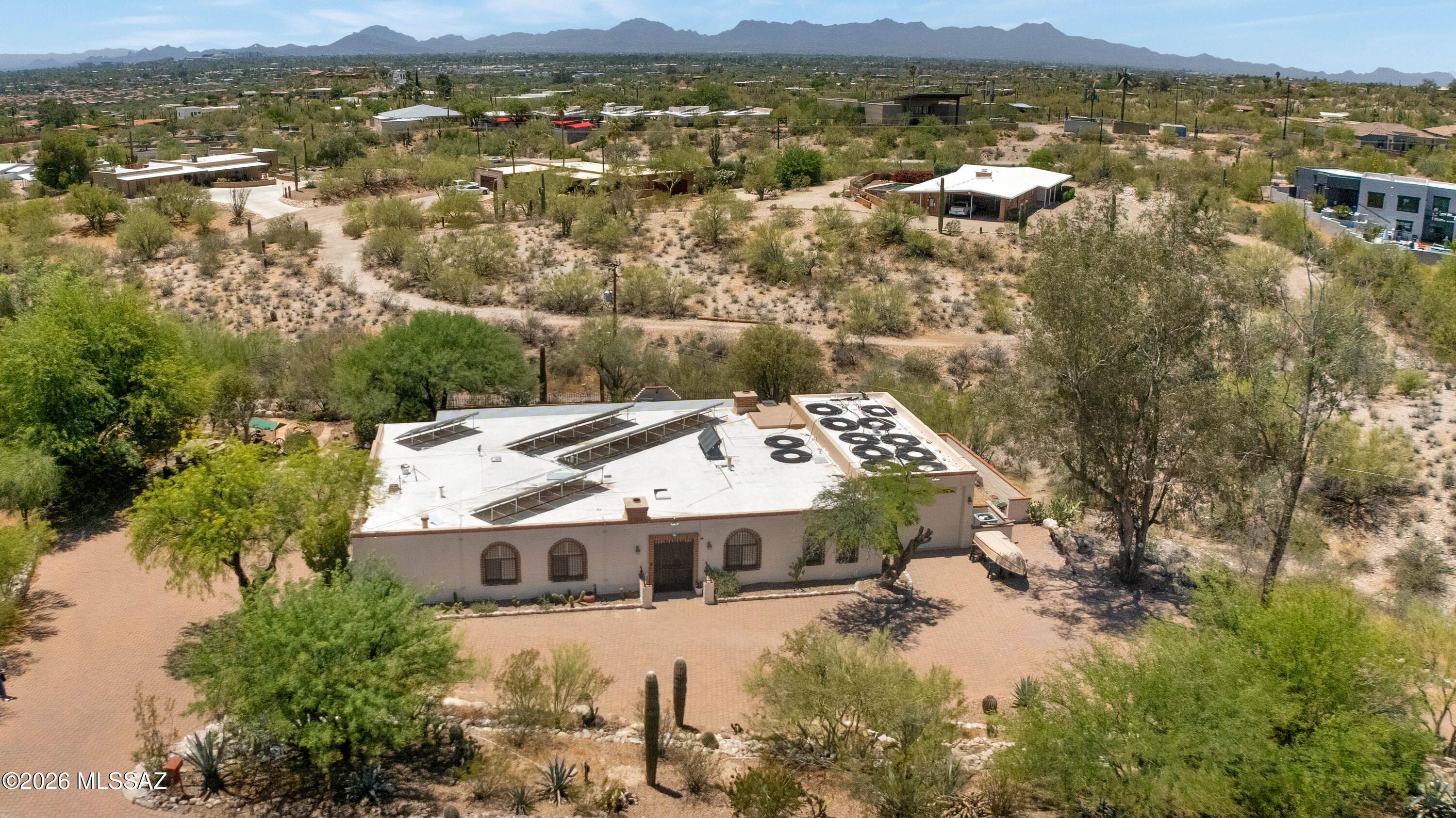 Reduced. Price range listing. Seller will consider offers between 675-700,000. Classic Southwestern burnt adobe territorial home on over 1.4 acres in the fabulous Catalina Foothills. Wonderful paver circular driveway. Versatile floor plan with open kitchen to large dining room, or family room with beamed ceilings and bee hive fireplace. Large windows showcase the mountain view. Saltillo tile throughout main living areas. Separate living room and dining area. Kitchen boasts granite counter tops, stainless steel appliances, raised panel wood cabinetry, electric range with double ovens and built in microwave oven. Full length covered rear patio overlooking the pool. Recently added turf. Three car garage, plus additional RV garage.