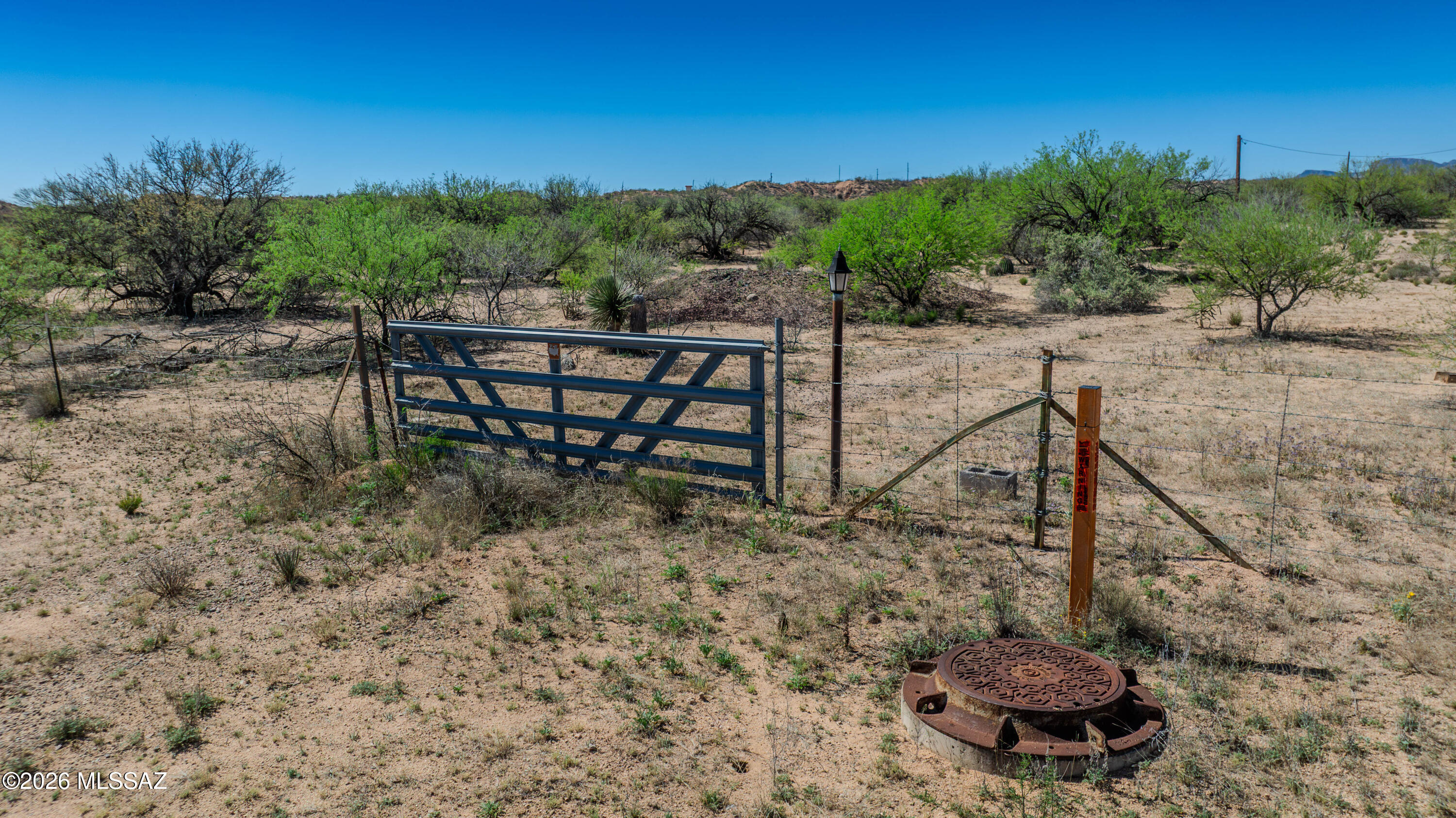 Nine acres+ of open San Pedro Valley land with direct Highway 80 frontage, a gated entry, and 2/3 well ownership in the legal description. Electric, septic, and well are all in place. Native mesquite and desert scrub blanket the parcel -- the kind of deep green you don't expect in Southern Arizona until you learn this valley sits on St. David's aquifer, one of the most reliable water tables in the region. It has quietly supported agriculture, horses, and livestock for generations. No structures. No HOA. Same family since 2002. Benson is 7 miles north with restaurants, a hospital, and I-10 access. Tucson is an hour northwest. If you've been looking for a piece of Southern Arizona that feels like a find -- because it is -- this is worth a closer look.